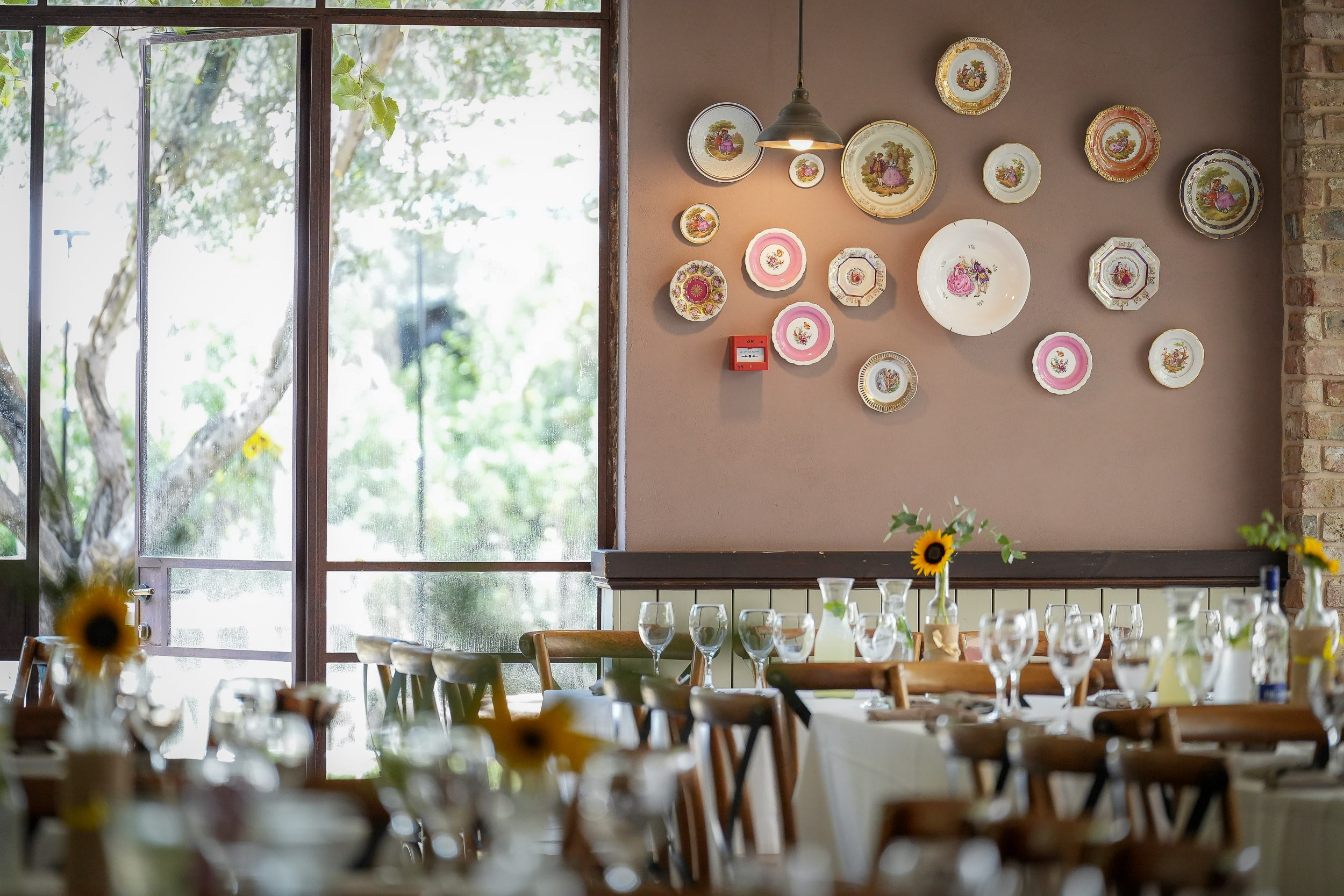 Reception tables are arranged beside vintage wall decorations at Villa Nona