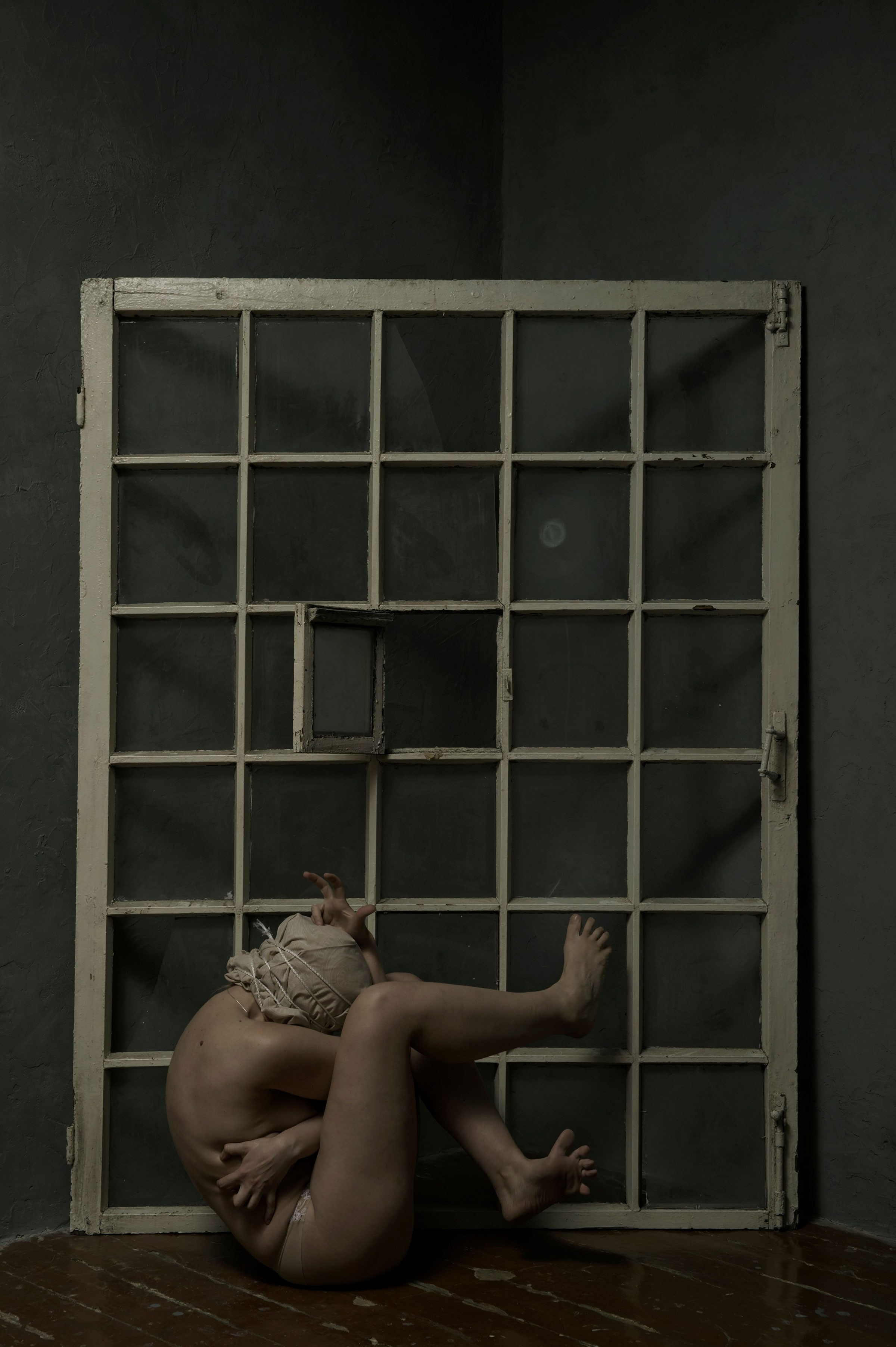 Conceptual image depicting a solitary woman in a domestic setting, surrounded by white chairs and reflective surfaces, from Leni Smoragdova's 'Figures Collection: She Would Buy the Flowers Herself' (2023).