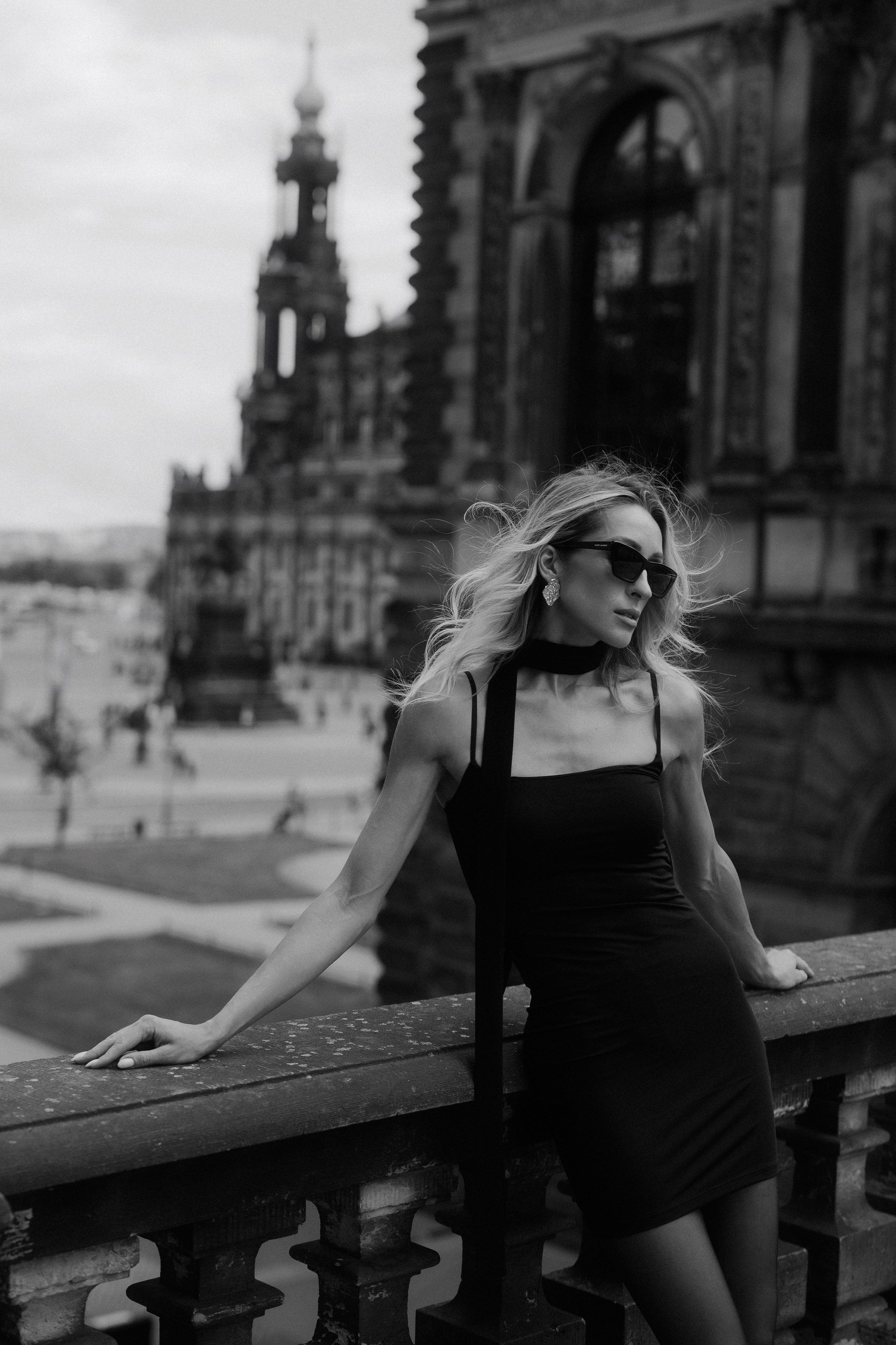 Black and white fashion portrait of an elegant woman in a black dress posing on a historic terrace in Dresden, Germany. Editorial female portrait photography inspired by timeless elegance, available in Dresden, Leipzig and Wurzen. Чёрно-белый fashion-портрет элегантной девушки в чёрном платье на исторической террасе в Дрездене, Германия. Редакционная женская фотография, вдохновлённая вневременной элегантностью, в Дрездене, Лейпциге и Вурцене.