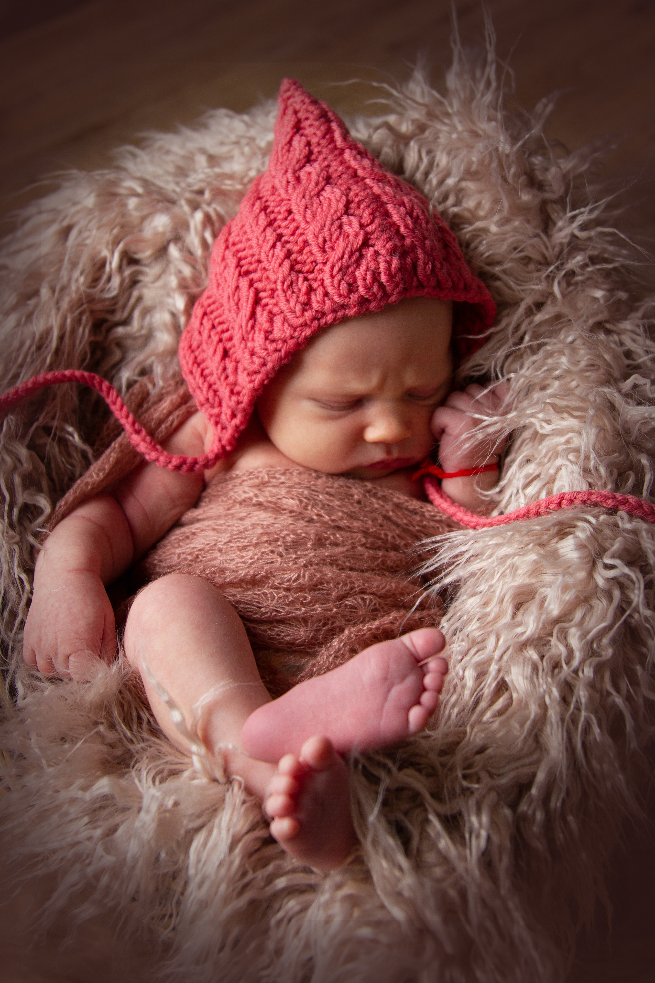 Eine kleine Prinzessin posiert in einem kuscheligen Korb und zeigt ihre entzückenden pinkfarbenen Accessoires