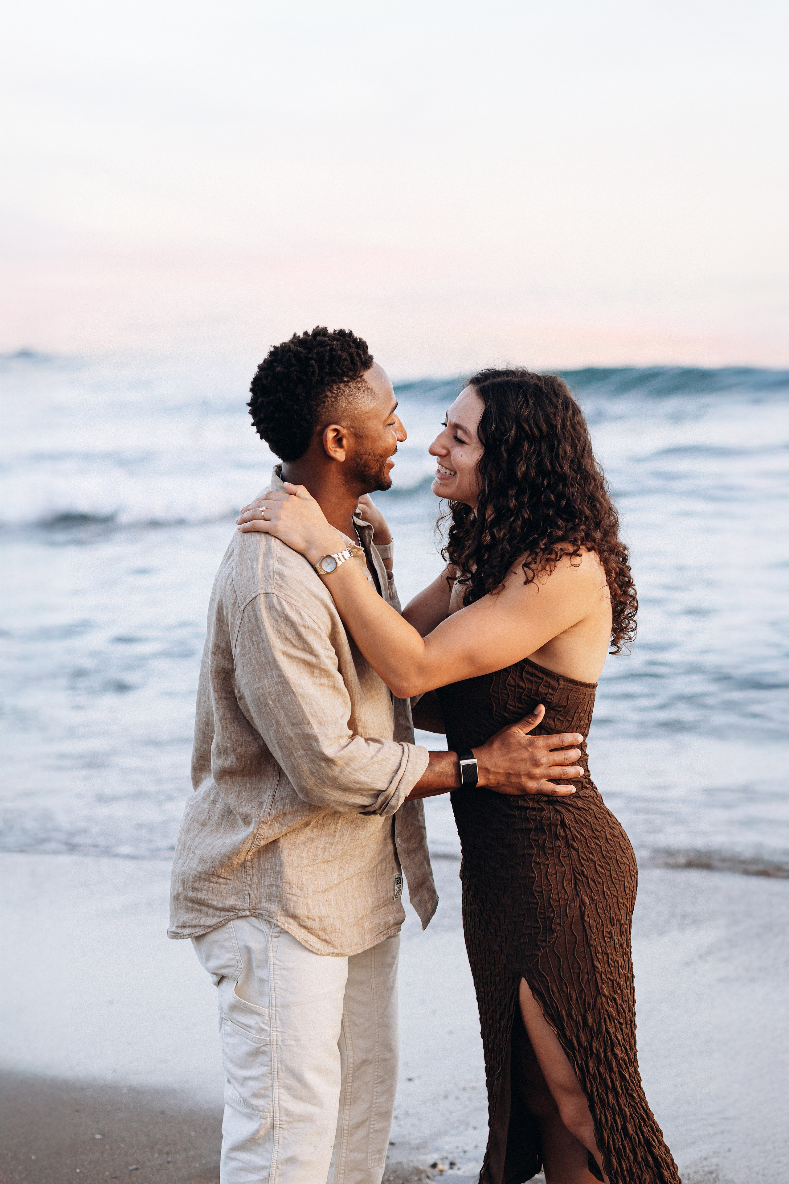 Romantic destination engagement session on a Málaga beach with the Mediterranean Sea behind the couple. Intimate post-proposal moment captured during a sunset engagement photoshoot on Spain’s Costa del Sol.