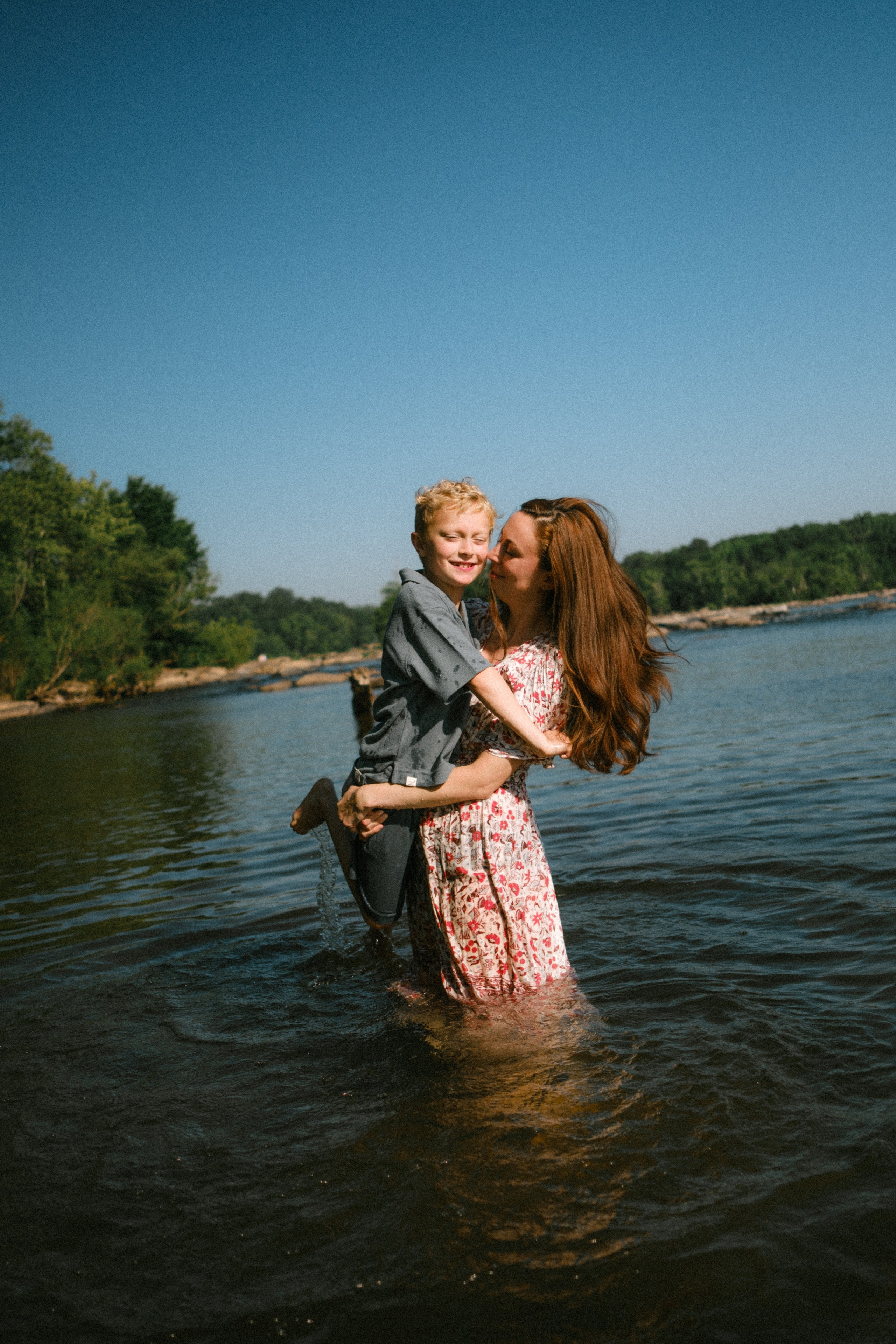 Beautiful, cinematic family portrait capturing a genuine, unposed moment on the river rocks in Richmond, VA
