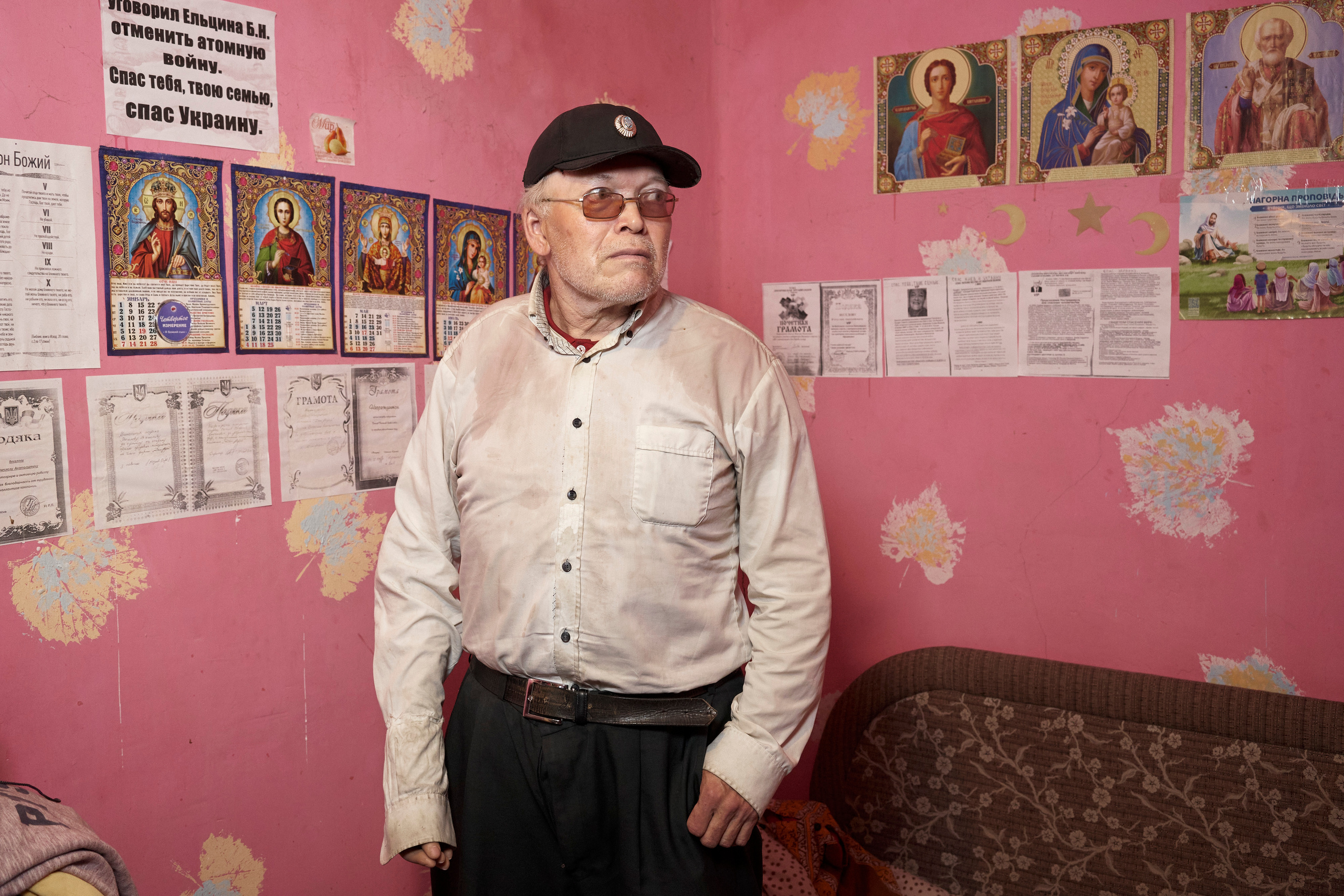 Viacheslav Veselov (aka ‘Kotik’ — ‘kitty’ from Russian) in his room. The wall is covered with images of Orthodox saints, photo copies of his diplomas and the inscription that says: «Convinced Yeltsin B. N. to cancel the atomic war. Saved yourself, your family, saved Ukraine.»