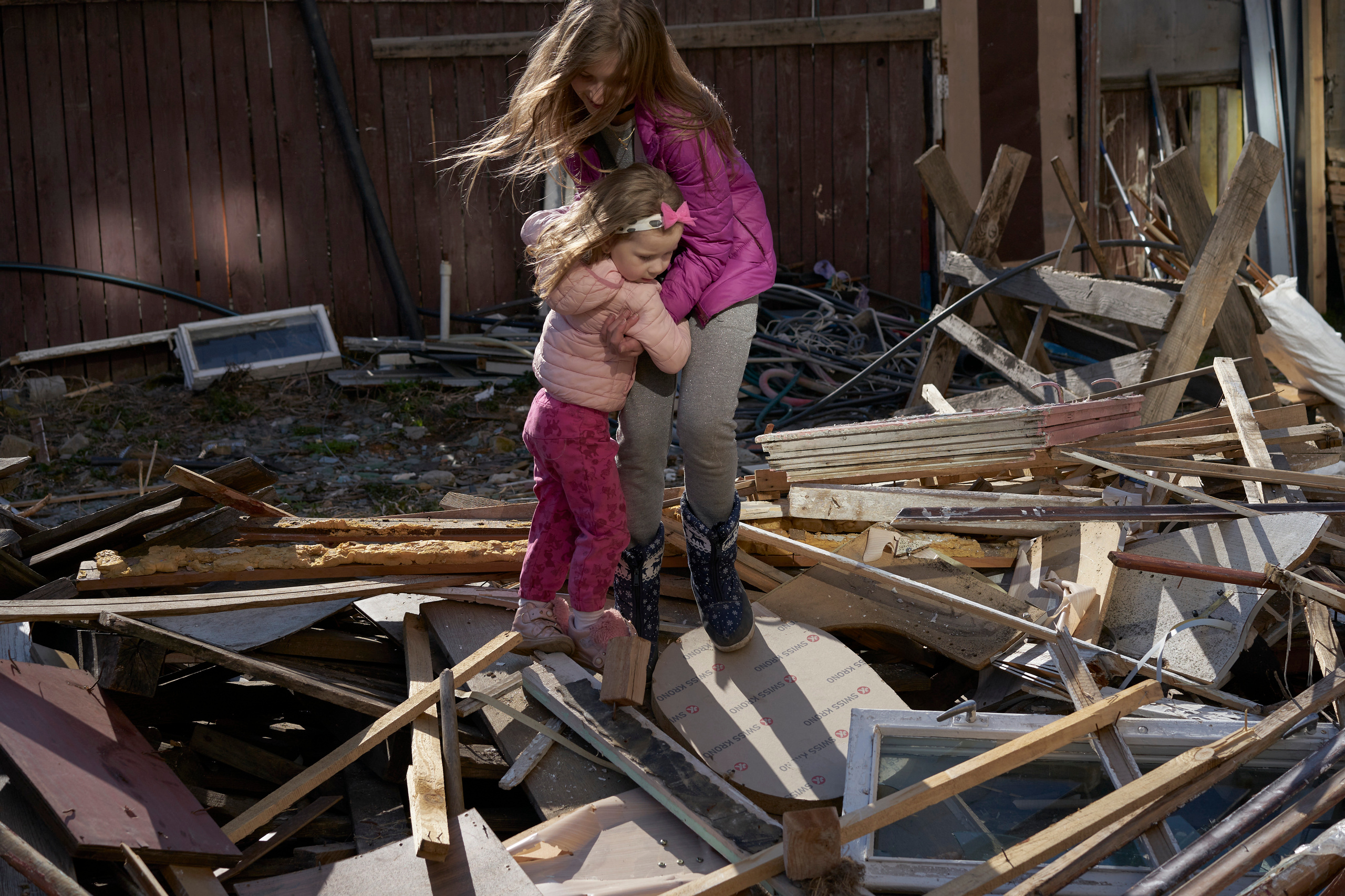 Two neighbor girls are playing on the construction debris heap in front of Natalia’s house.
