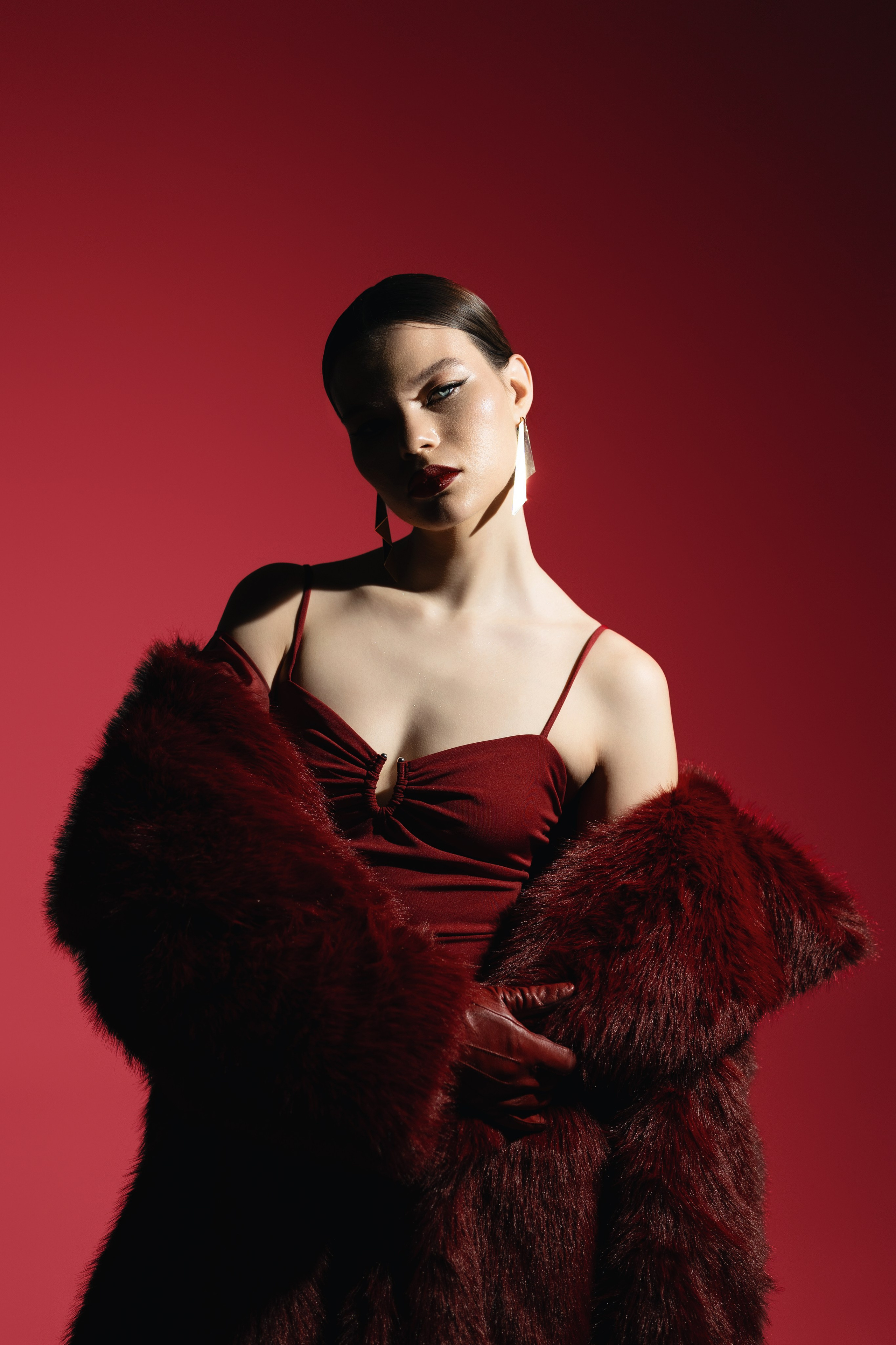 Dynamic Fashion Pose with Dramatic Lighting – A model posing in an avant-garde outfit, shot with bold lighting and high contrast to create a striking visual effect that highlights both the fashion and the model’s attitude