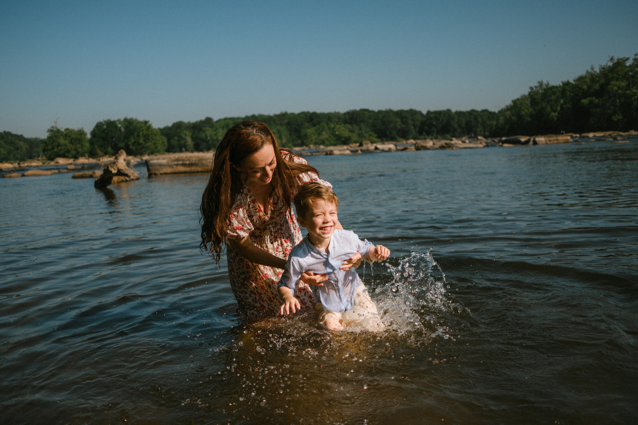 Beautiful, cinematic family portrait capturing a genuine, unposed moment on the river rocks in Richmond, VA