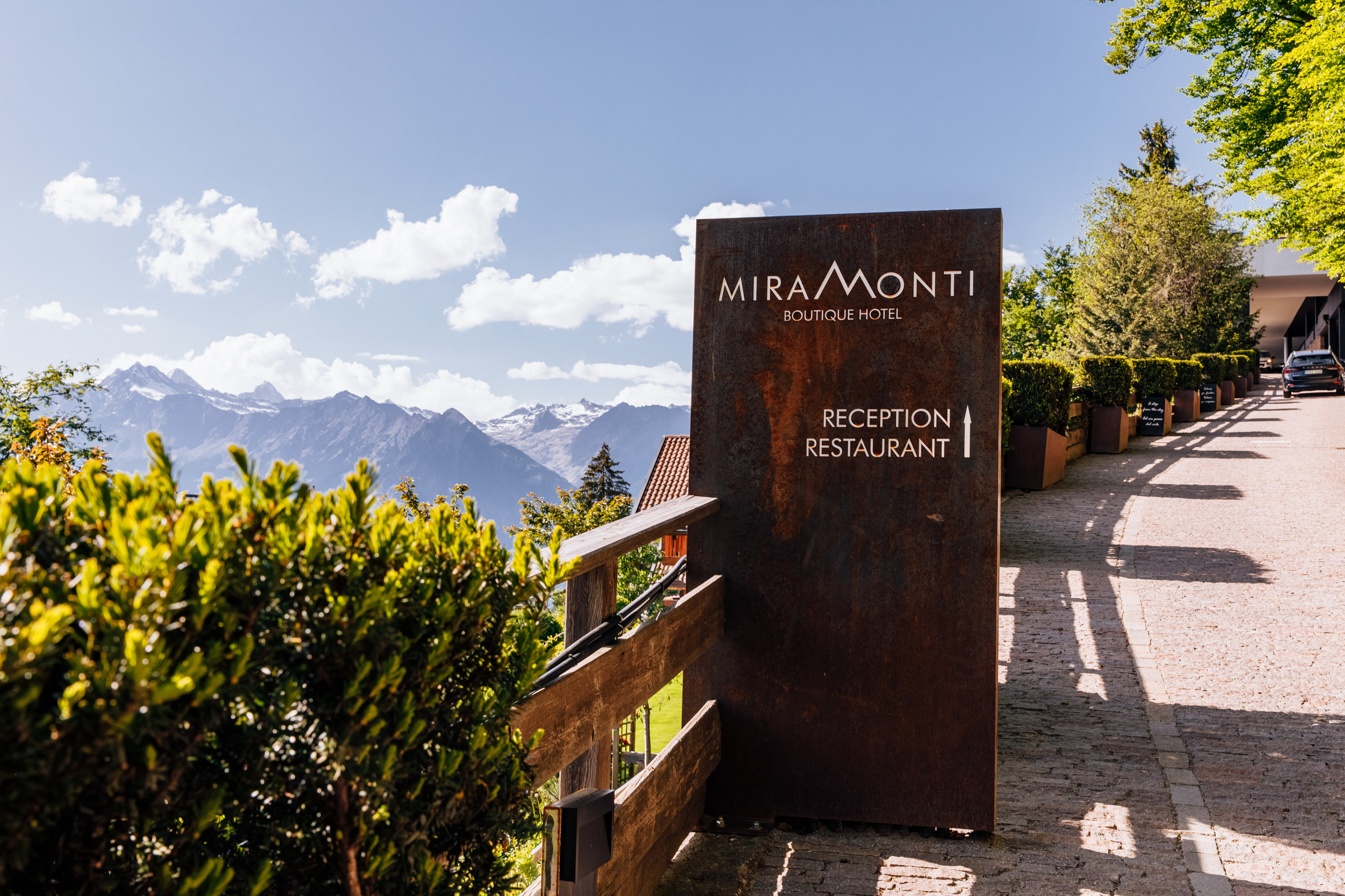 Die Hotel-Signatur des Miramonti Boutique Hotels im Südtirol, vor der beeindruckenden Bergkulisse. Ein perfektes Reiseziel für Hochzeitsgäste im malerischen Südtirol.