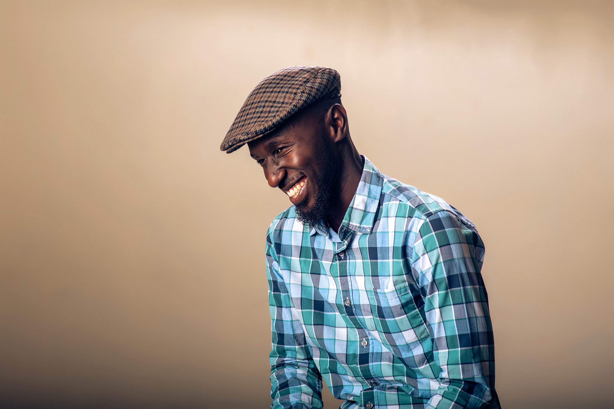 Man in casual checked shirt laughing — lifestyle portrait by Nick Ouma Photography, Nairobi, Kenya