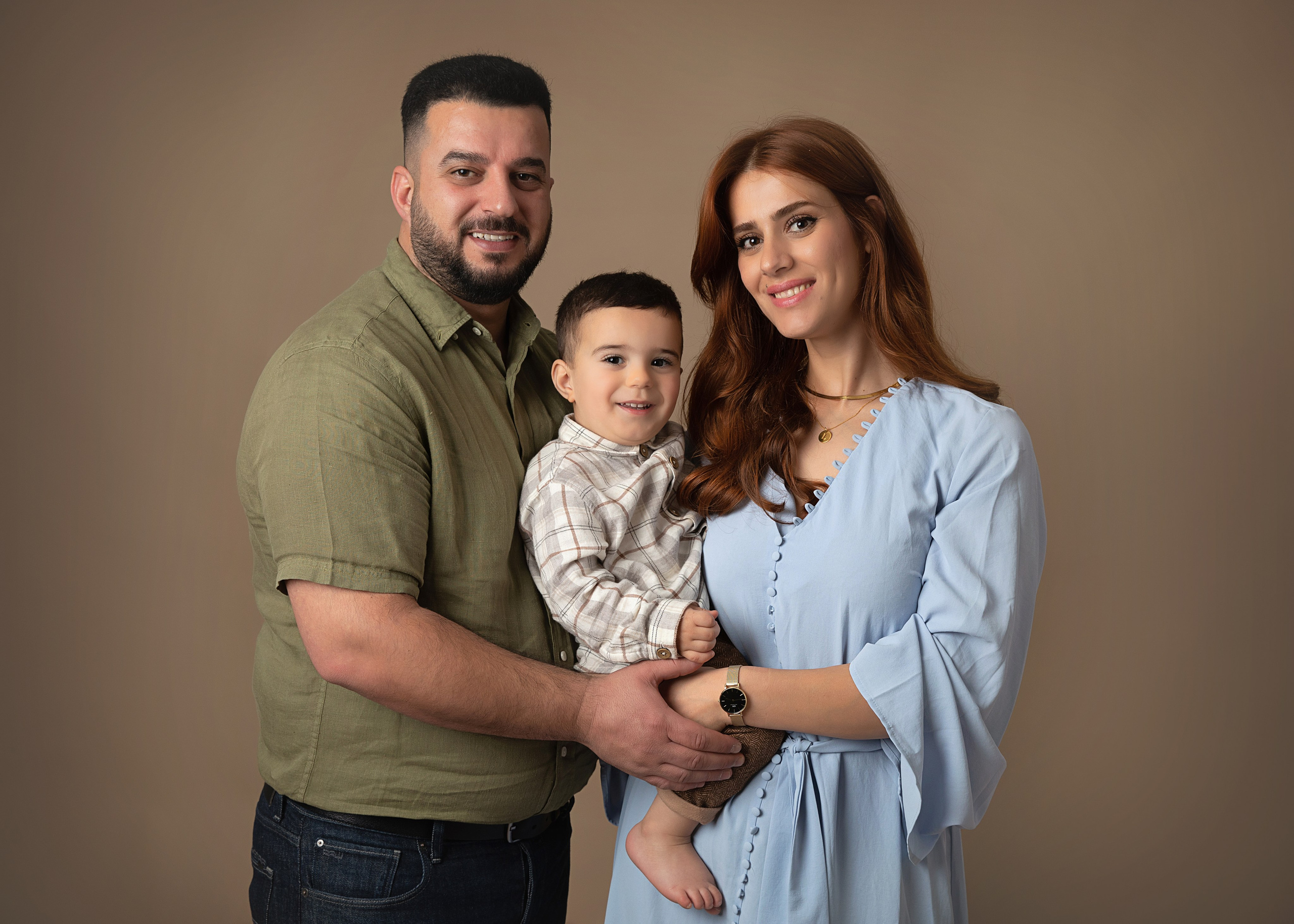 Mamma, pappa och barn tillsammans i en minnesvärd familjefotografering i vår fotostudio.