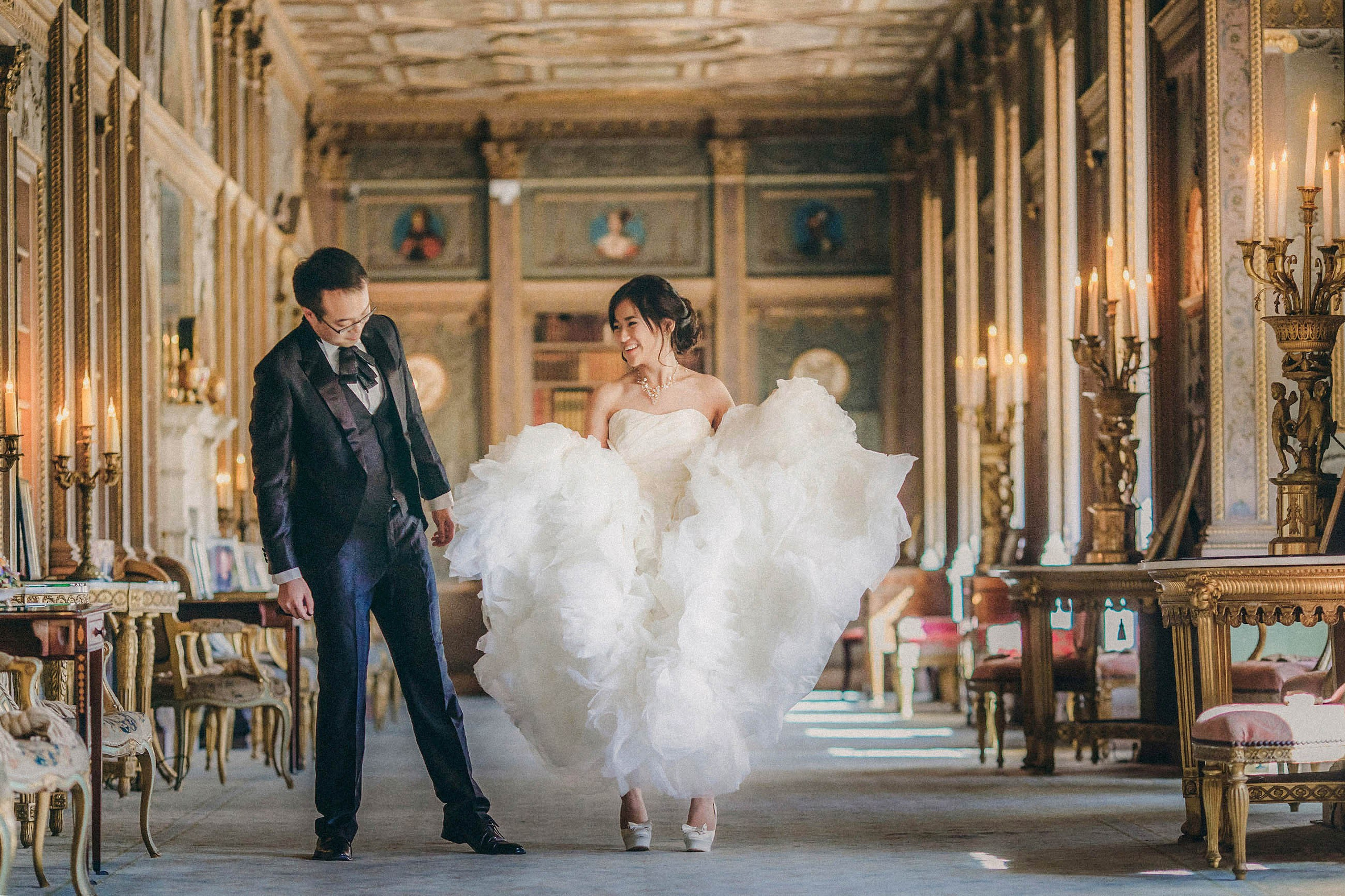 A Hong Kong groom looks at his bride's Jimmy Choo shoes as she lifts up her wedding dress during their wedding at the Syon House in London. 