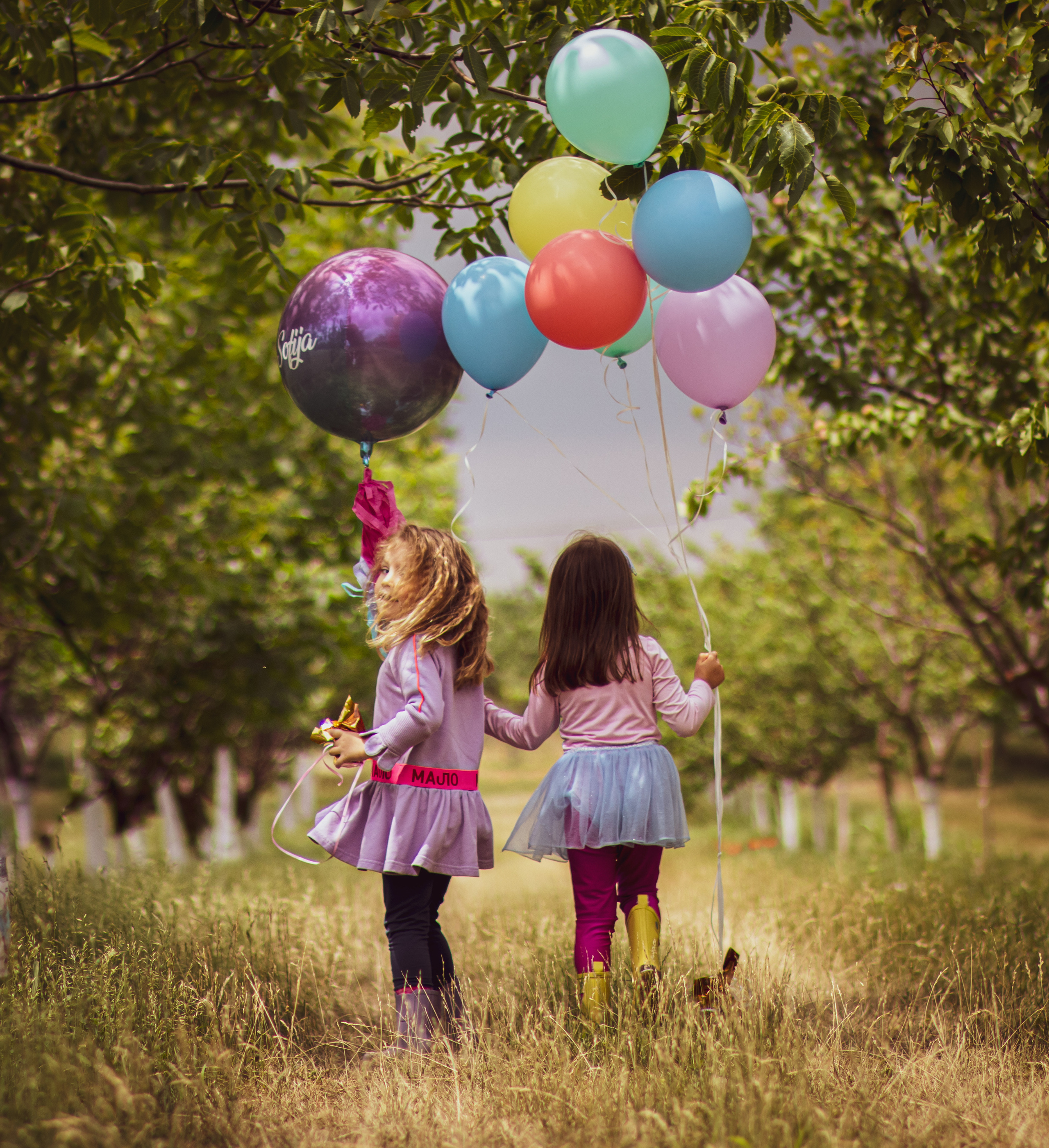 fotografija devojčica sa šarenim balonima