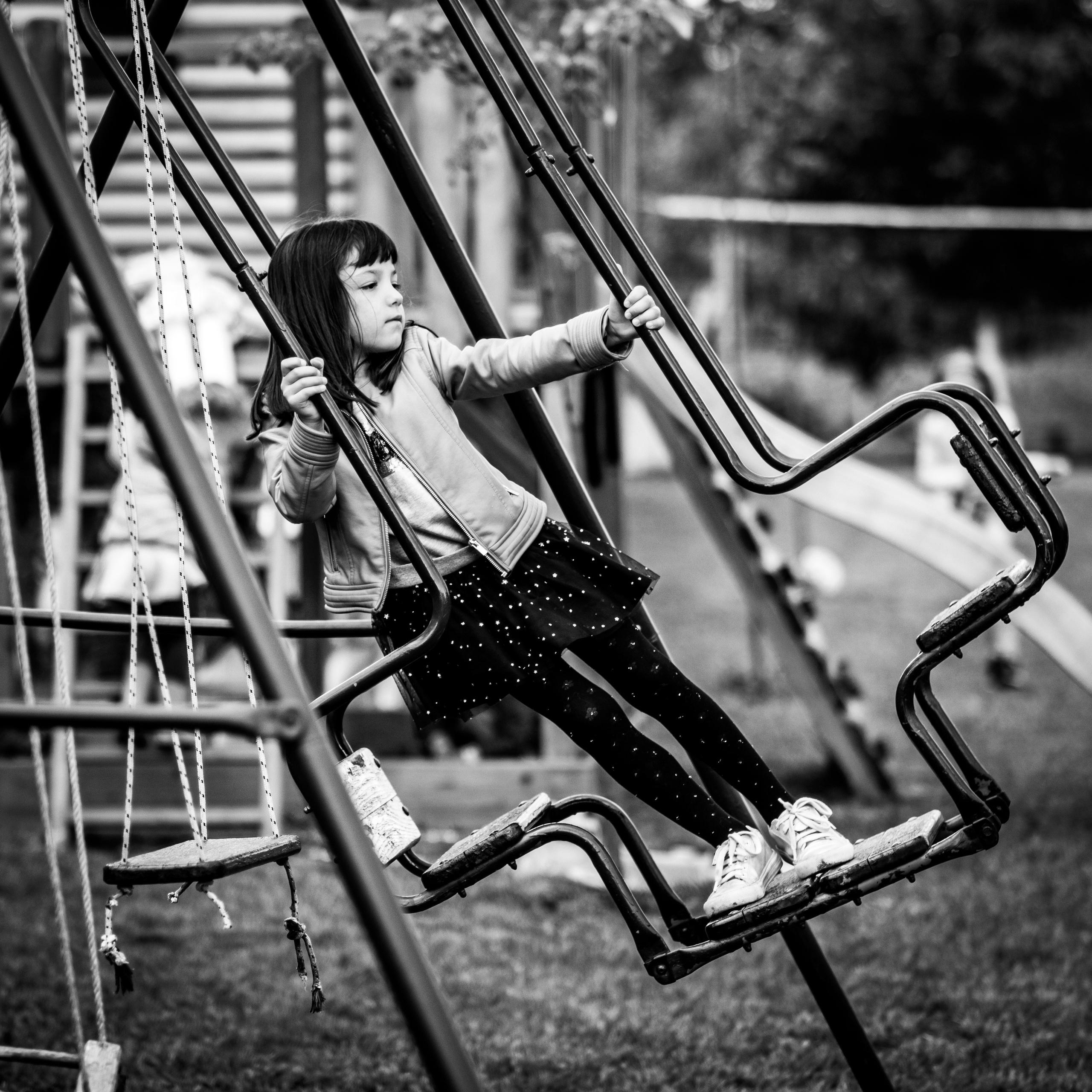 crno-bela fotografija devojčice na ljuljašci