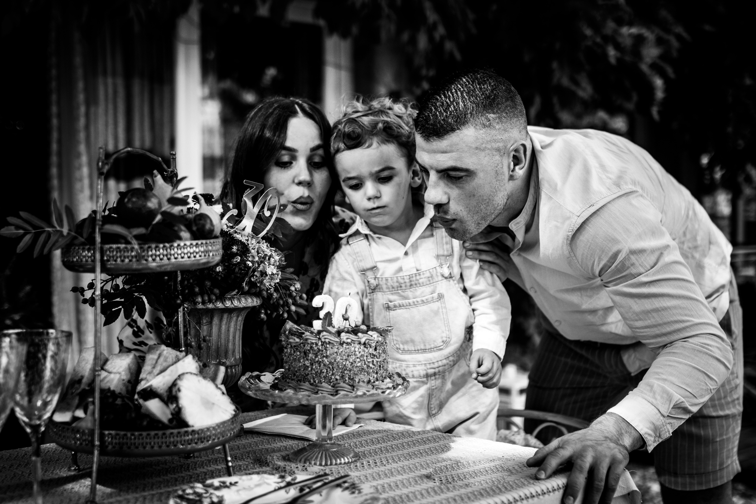 crno-bela porodična fotografija duvanja svećica