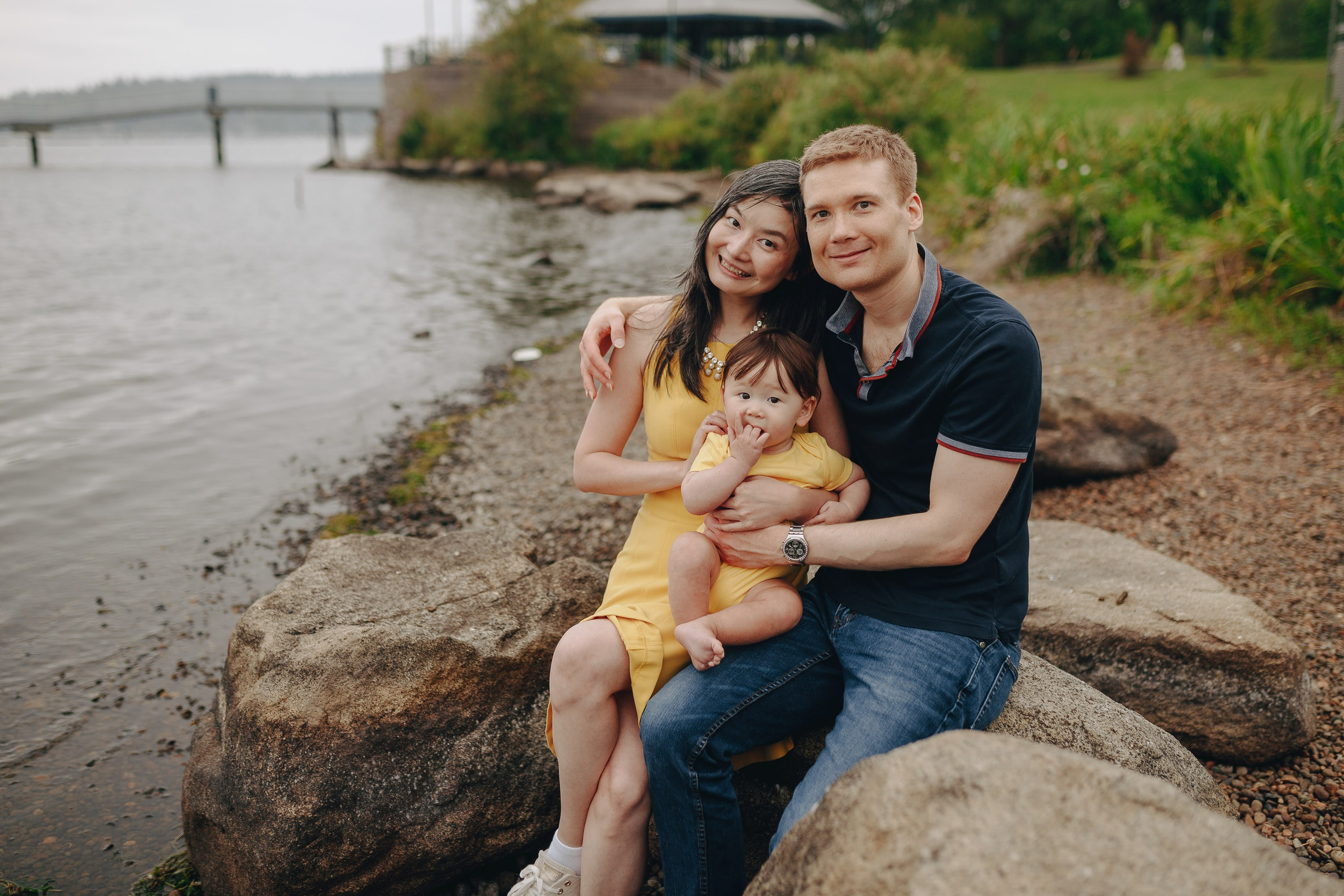 Family sitting by the water, relaxed outdoor session