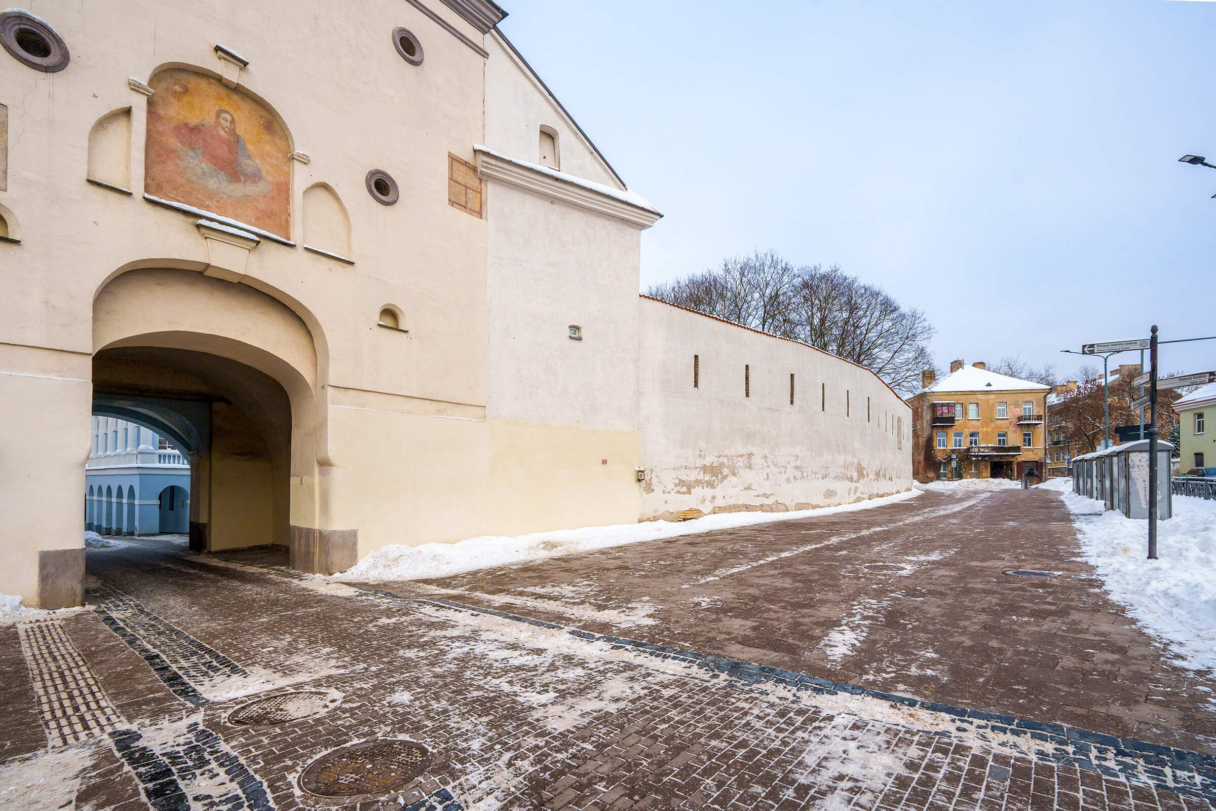 Senamiesčio fasadas su vaizdu į Aušros Vartus — kai net vartai atrodo romantiškiau už buvusįjį