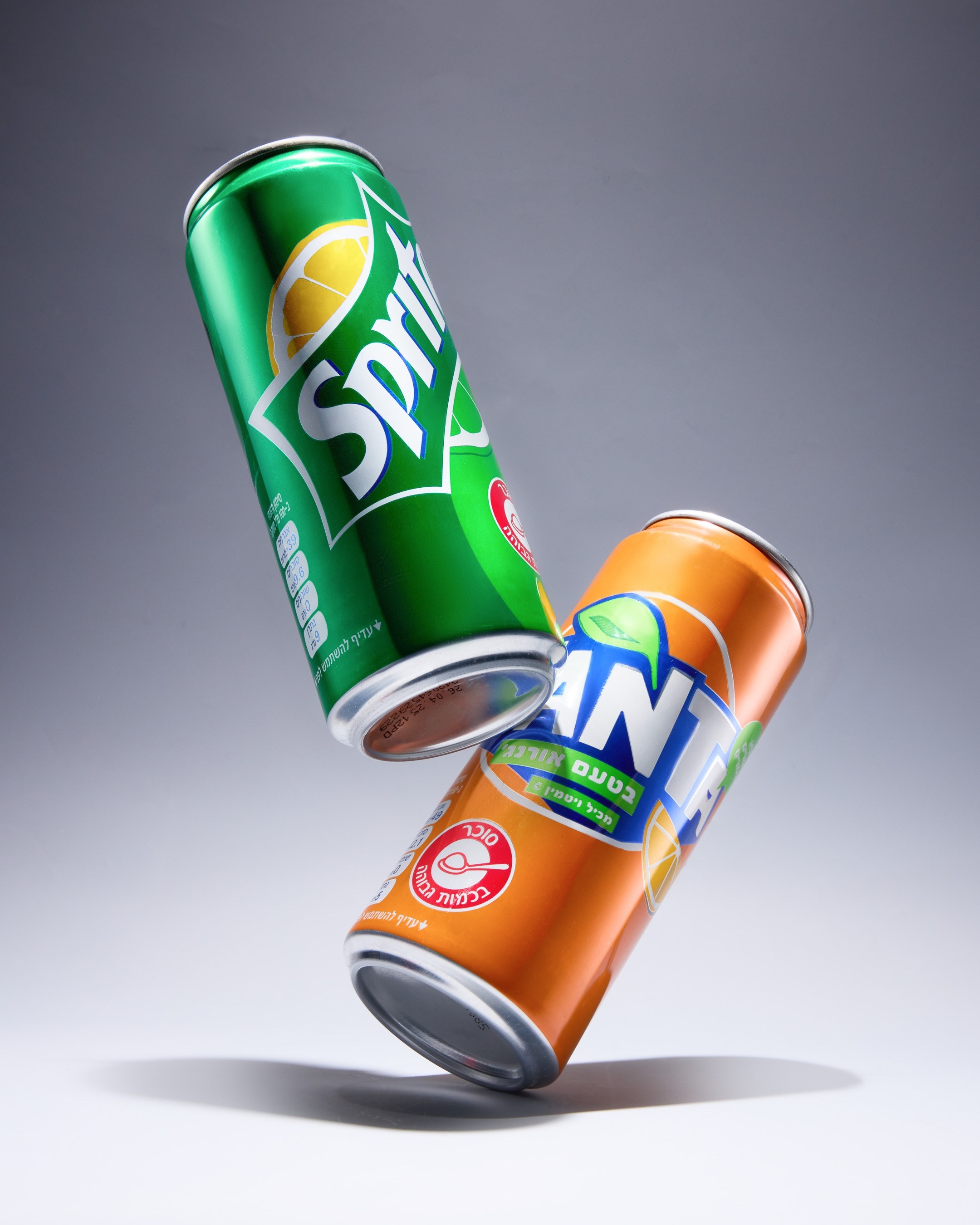 Levitating Sprite and Fanta cans on grey background - photographer Andrey Dunin