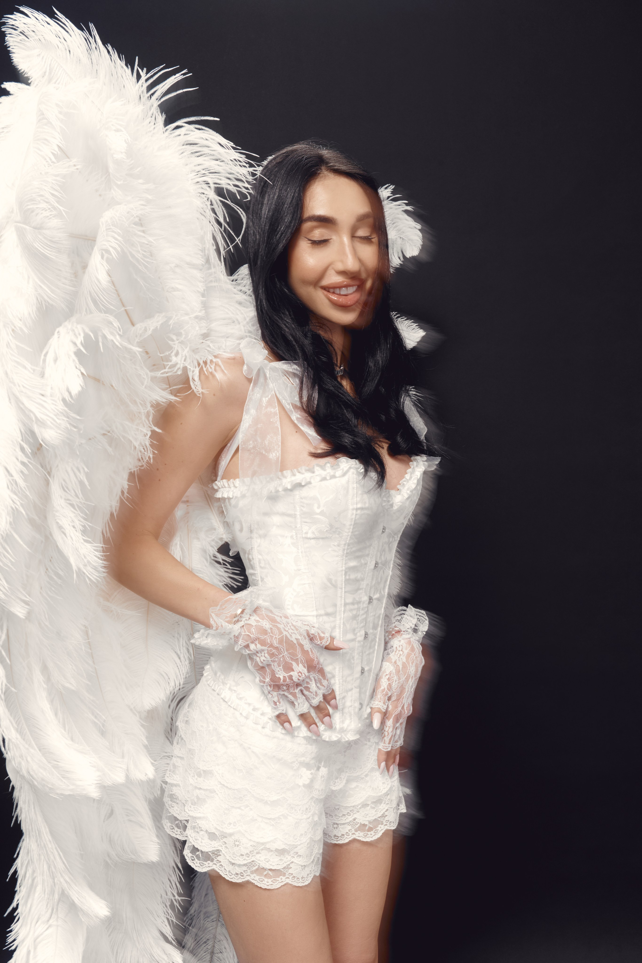 Modern editorial boudoir portrait of Ester Rogovaya in white lingerie-inspired outfit with wings