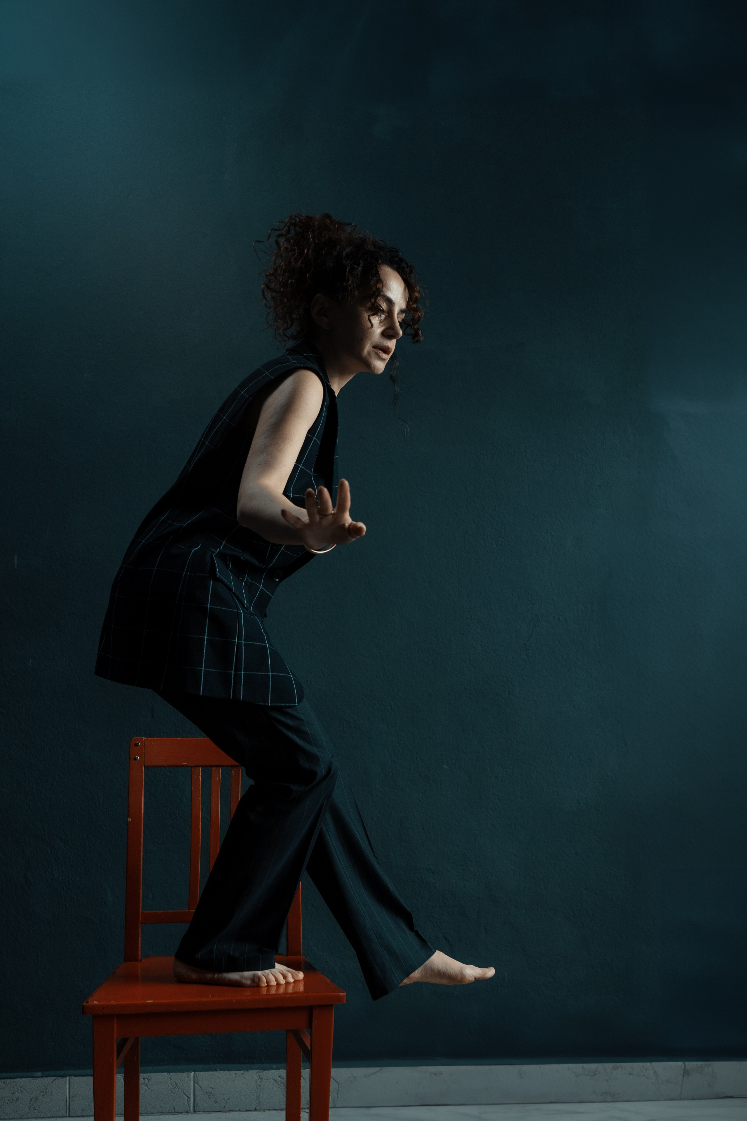 Ausdrucksstarkes Studio-Portrait, Frau auf Stuhl in schwarzem Anzug – künstlerische Fotografie