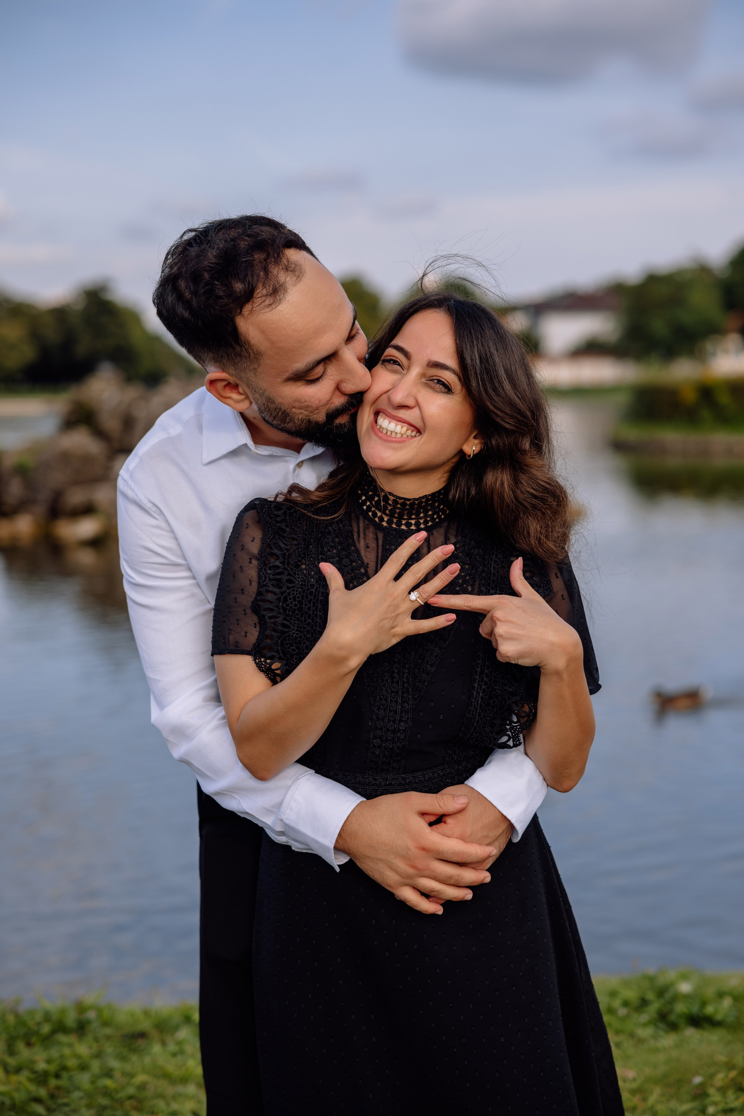 Nahaufnahme der Hände des Paares mit Verlobungsring vor dem Schloss Nymphenburg