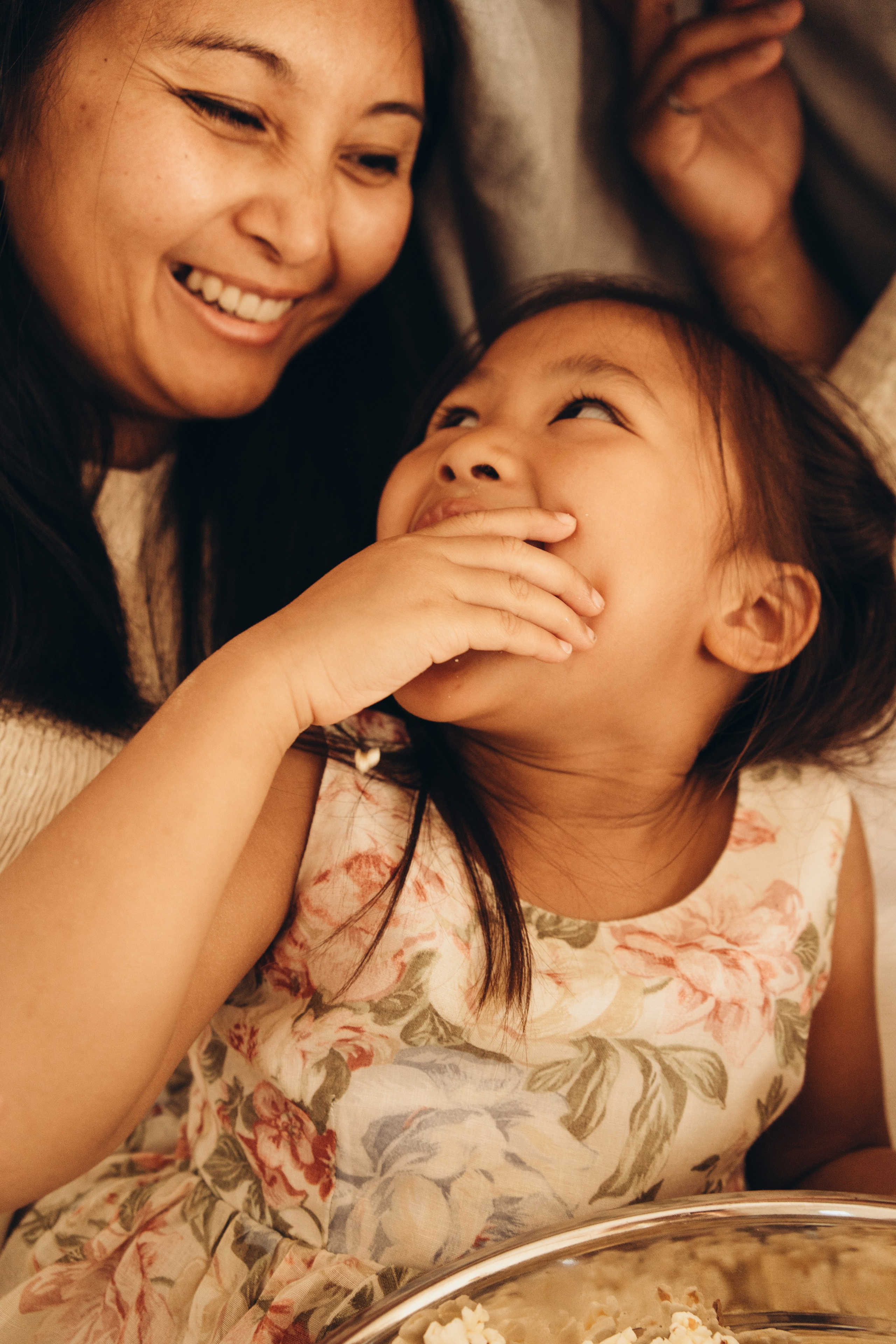 Close-up of a mother and her daughter laughing together