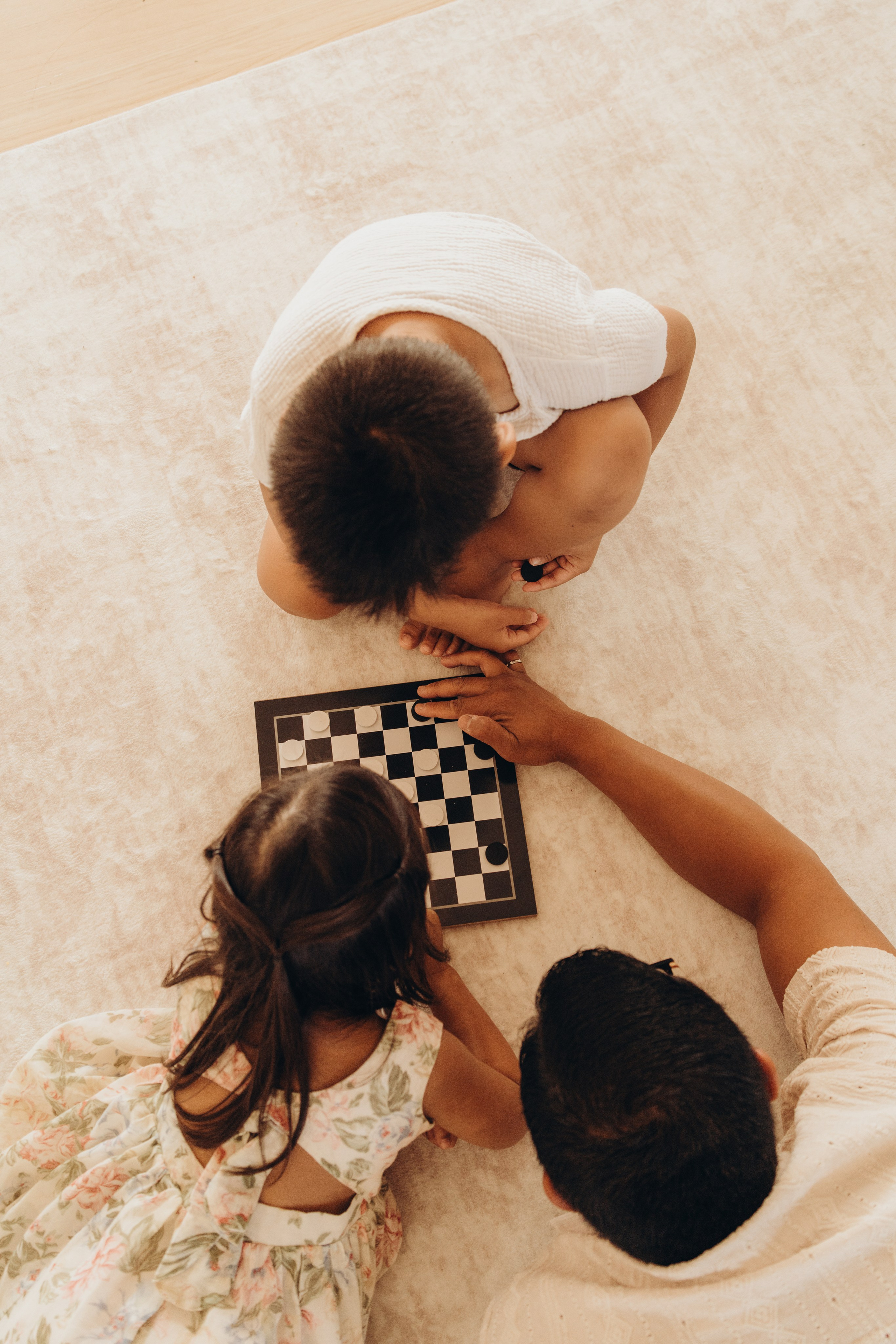 Children and parents gathered around a checkerboard, seen from above