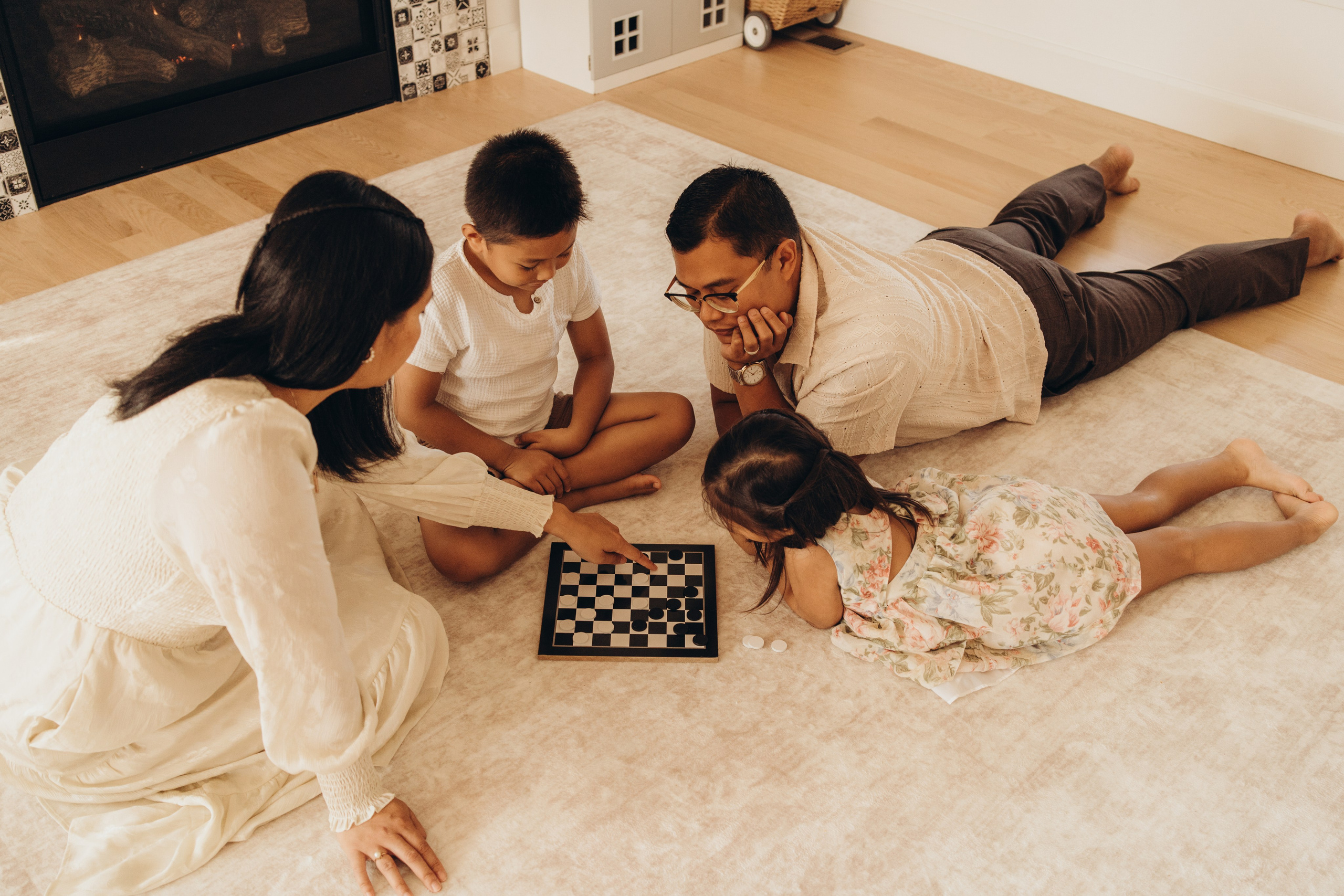 Family lying on the floor playing checkers together