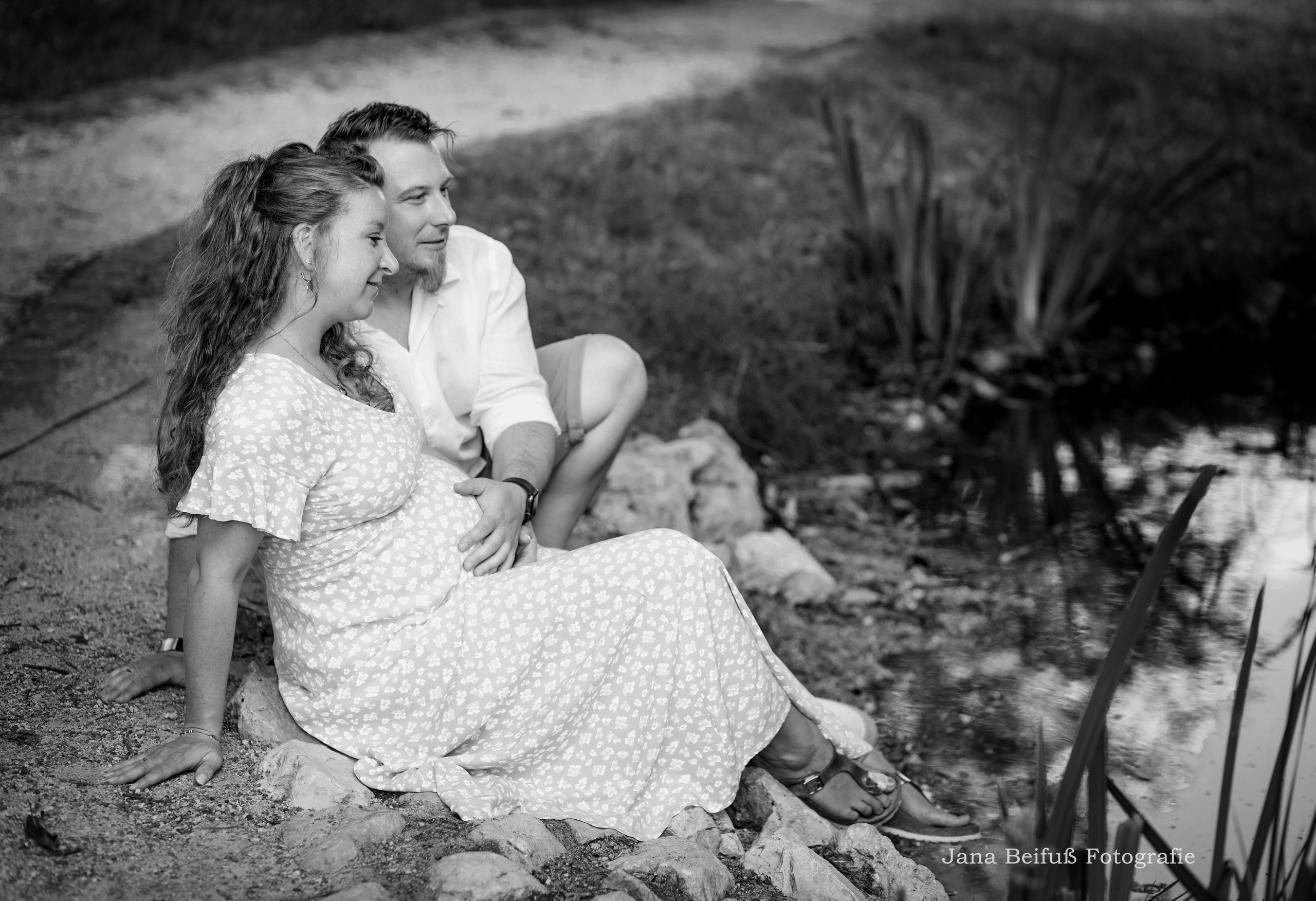 glückliche werdende Eltern am Teich Bild ist in schwarz weiß - Schwangerschaftsfotografie Weißenhorn bei Ulm
