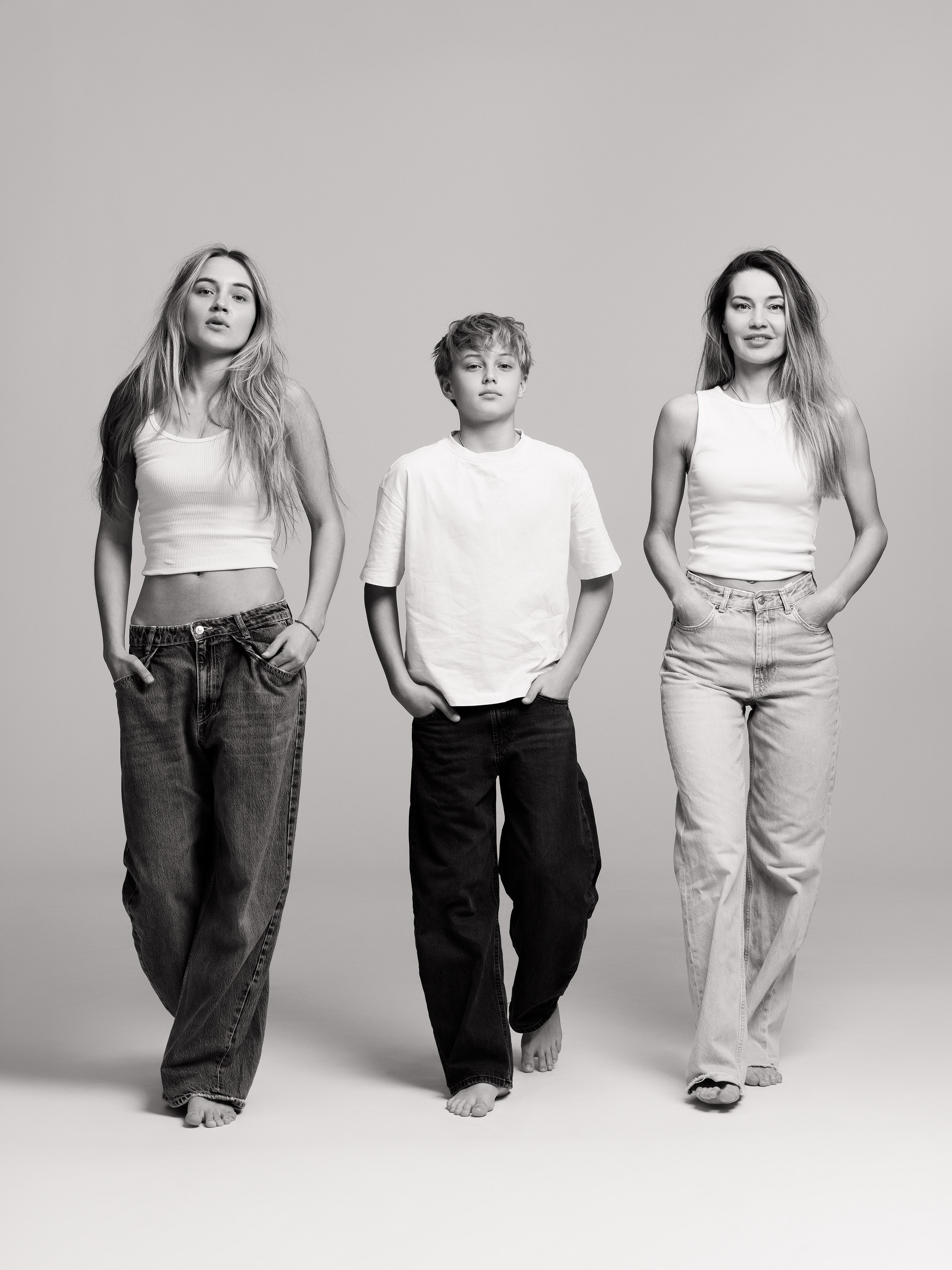 three teenage girls walking together in the studio, black and white