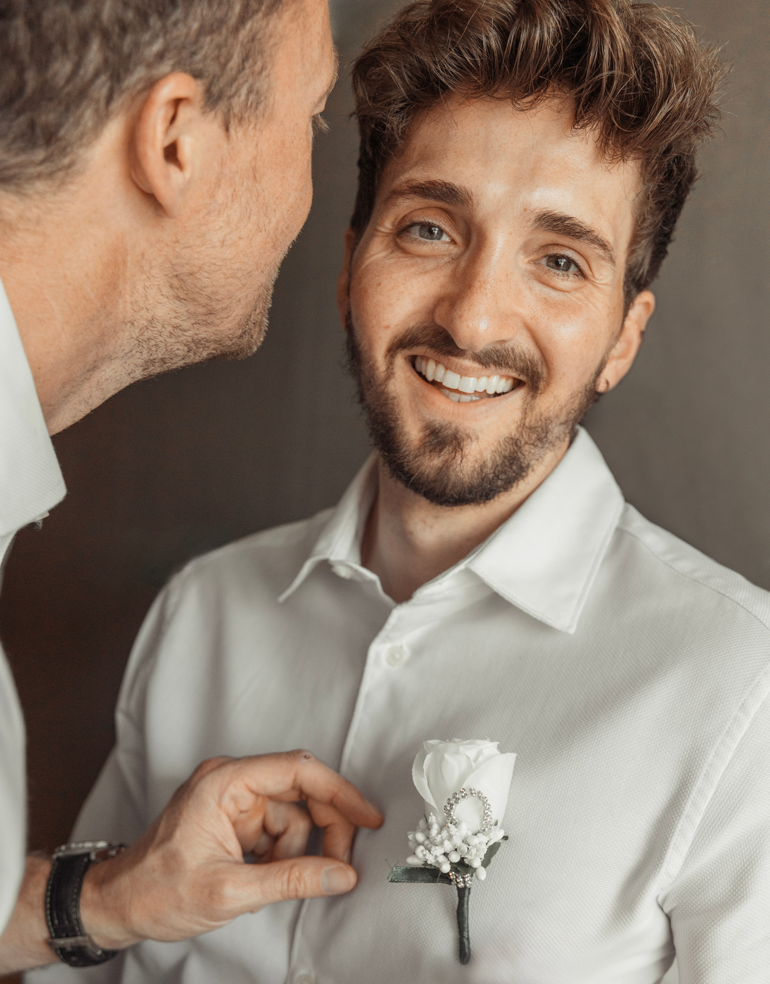 The groom's best man is putting a boutonniere to his friend. Rhodes, Greece.