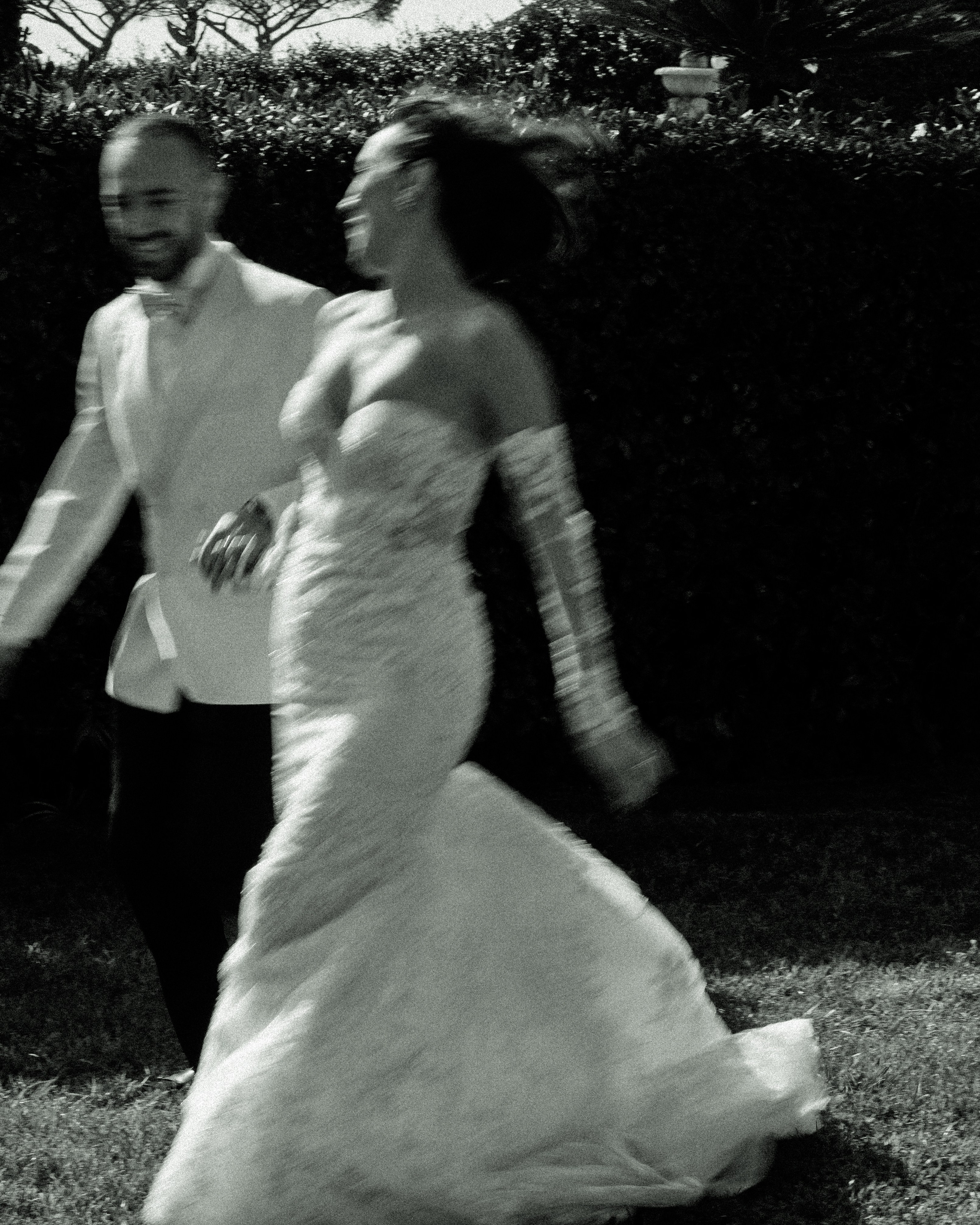 Blurred motion shot of bride and groom running together