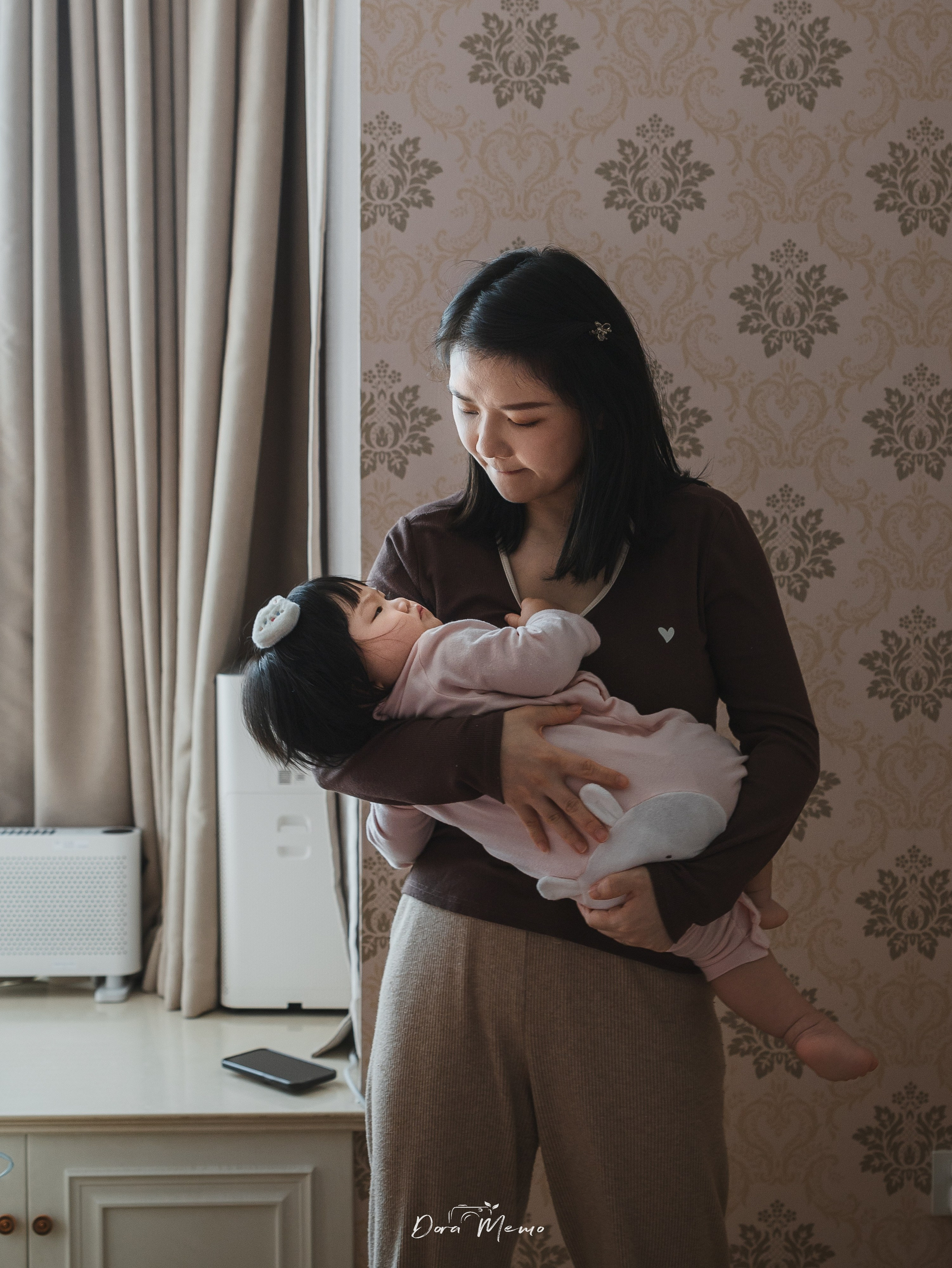 During the family photoshoot, mom gently rocked her baby to sleep.