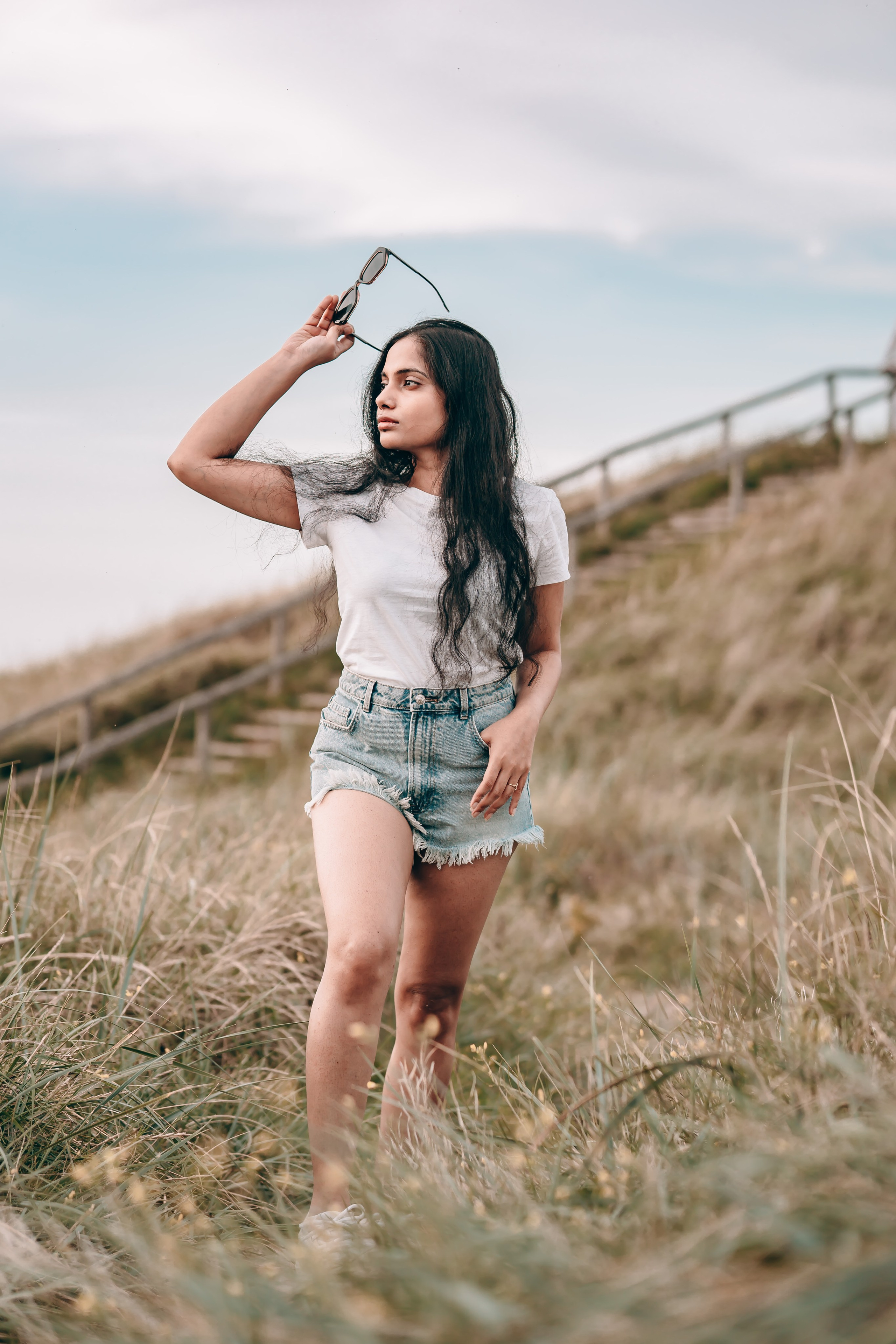 Woman walking along a narrow path close to the beach