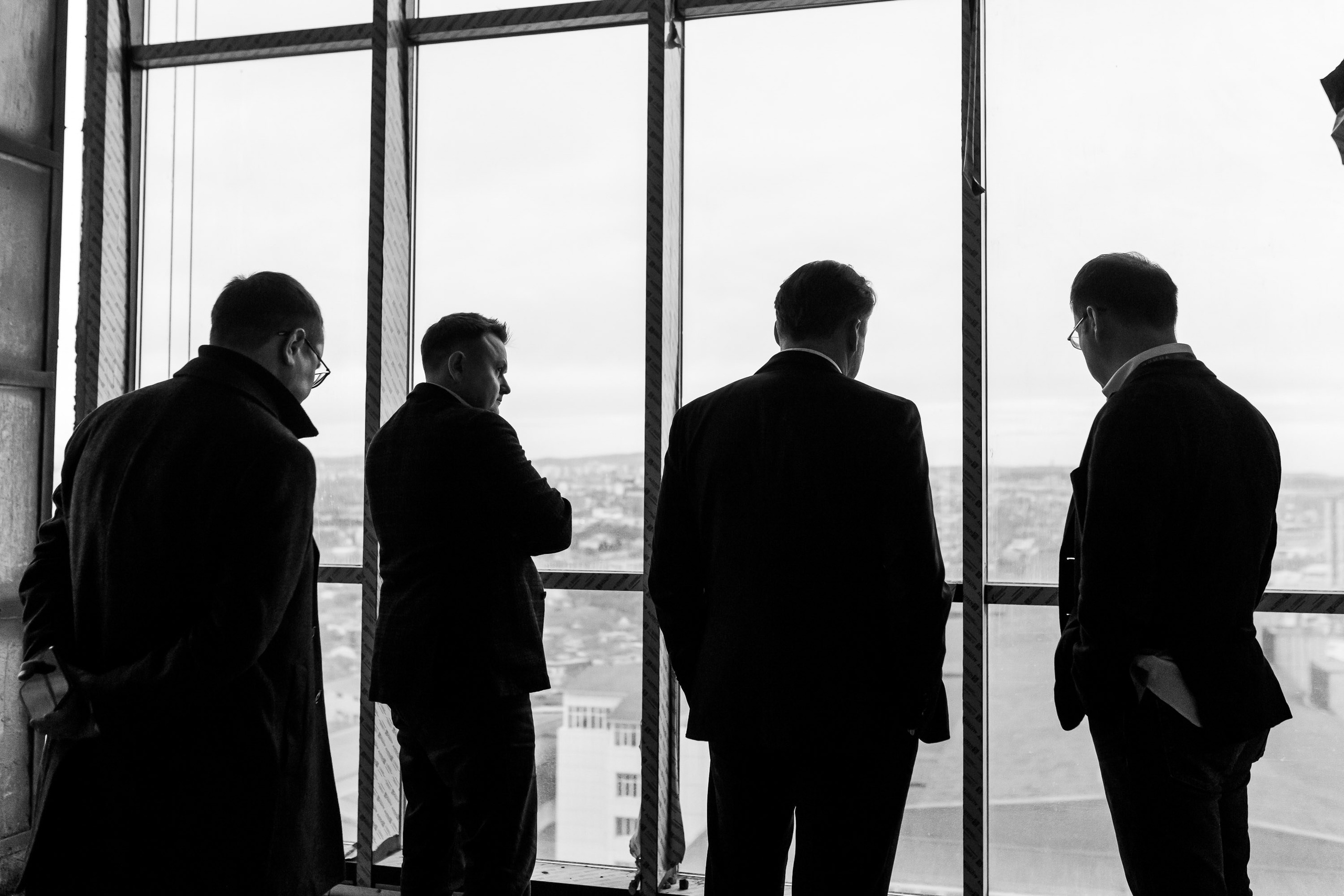 People standing by window, black and white candid shot