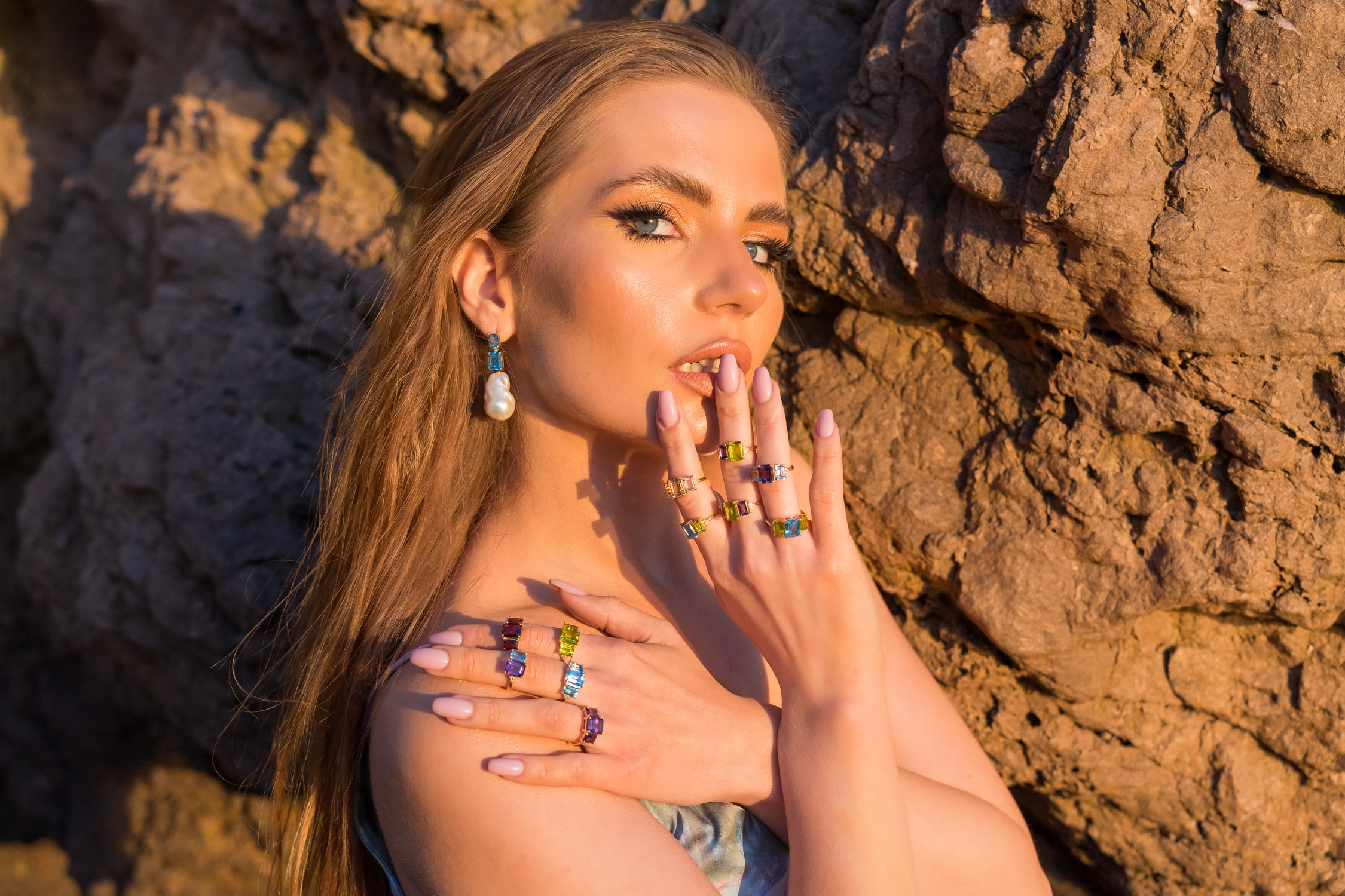 A beautiful girl wearing various rings from a local jewelry brand, standing on the beach in Malibu