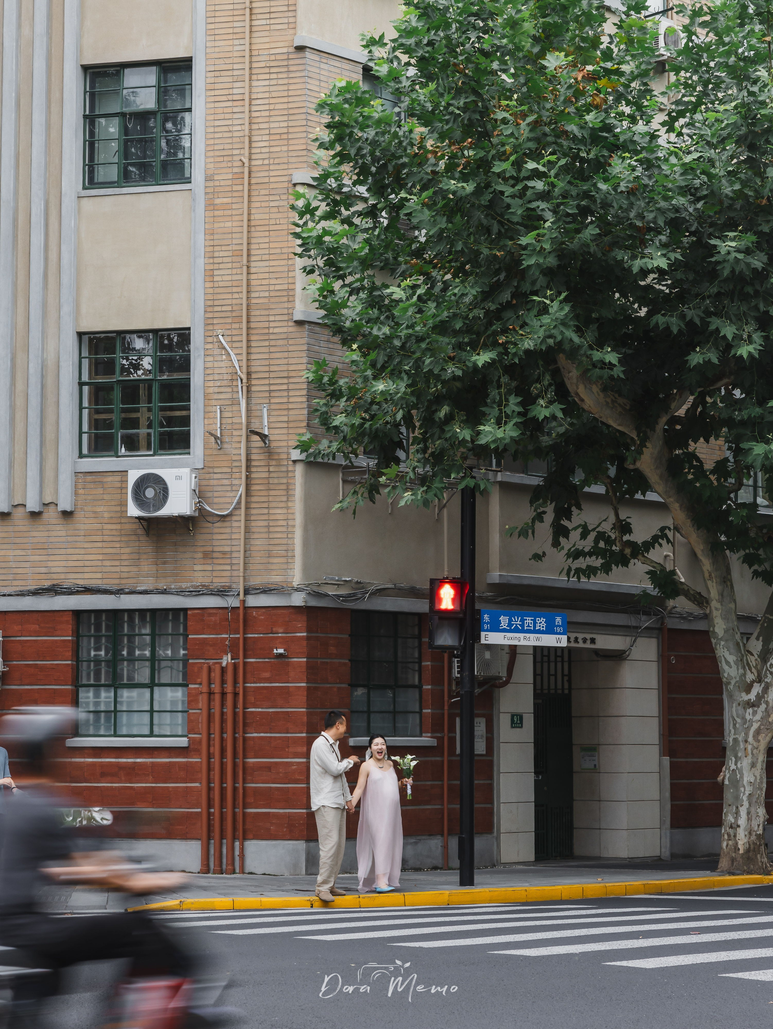 Expecting parents waiting at a crosswalk in the city, photographed by a Shanghai family photographer documenting real life before parenthood.