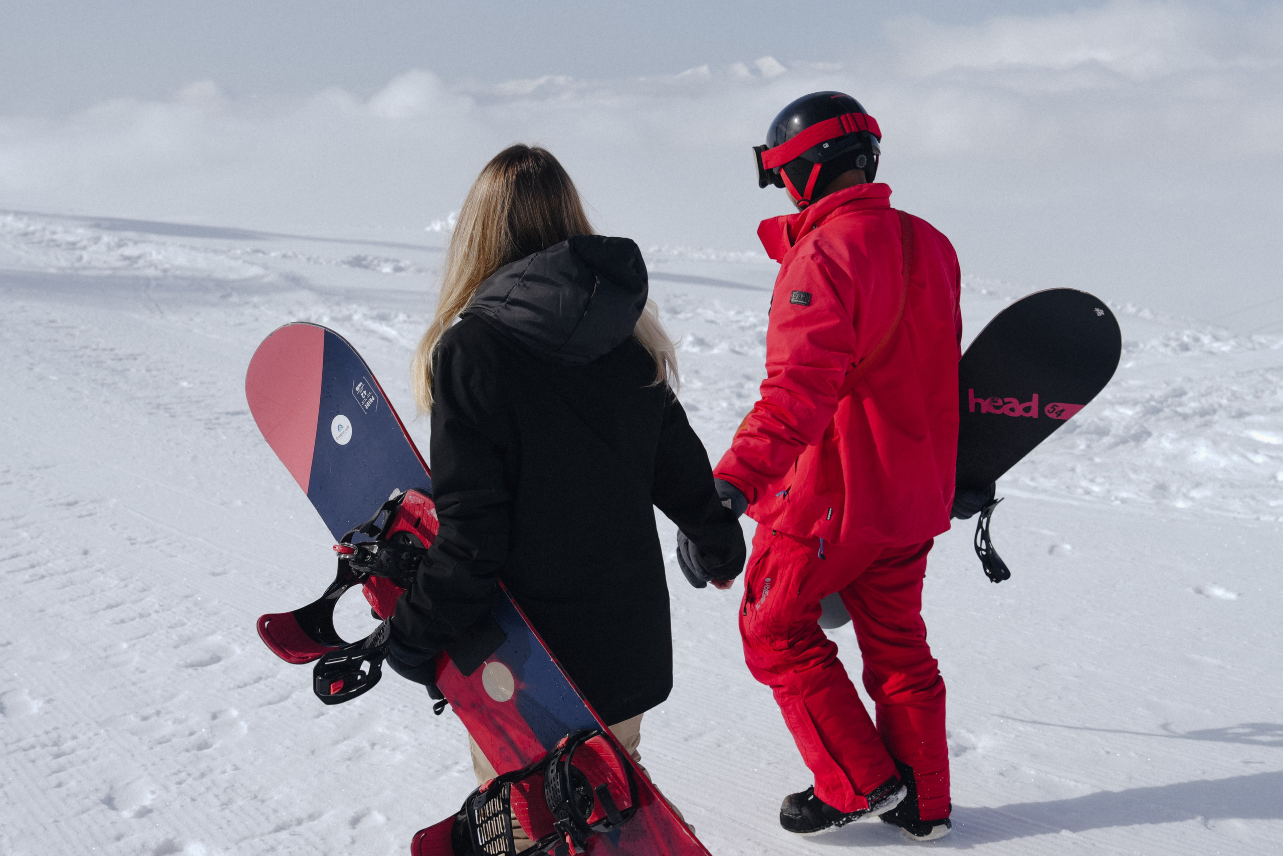 Couple of snowboarders walking hand by hand in Gudauri, Georgia