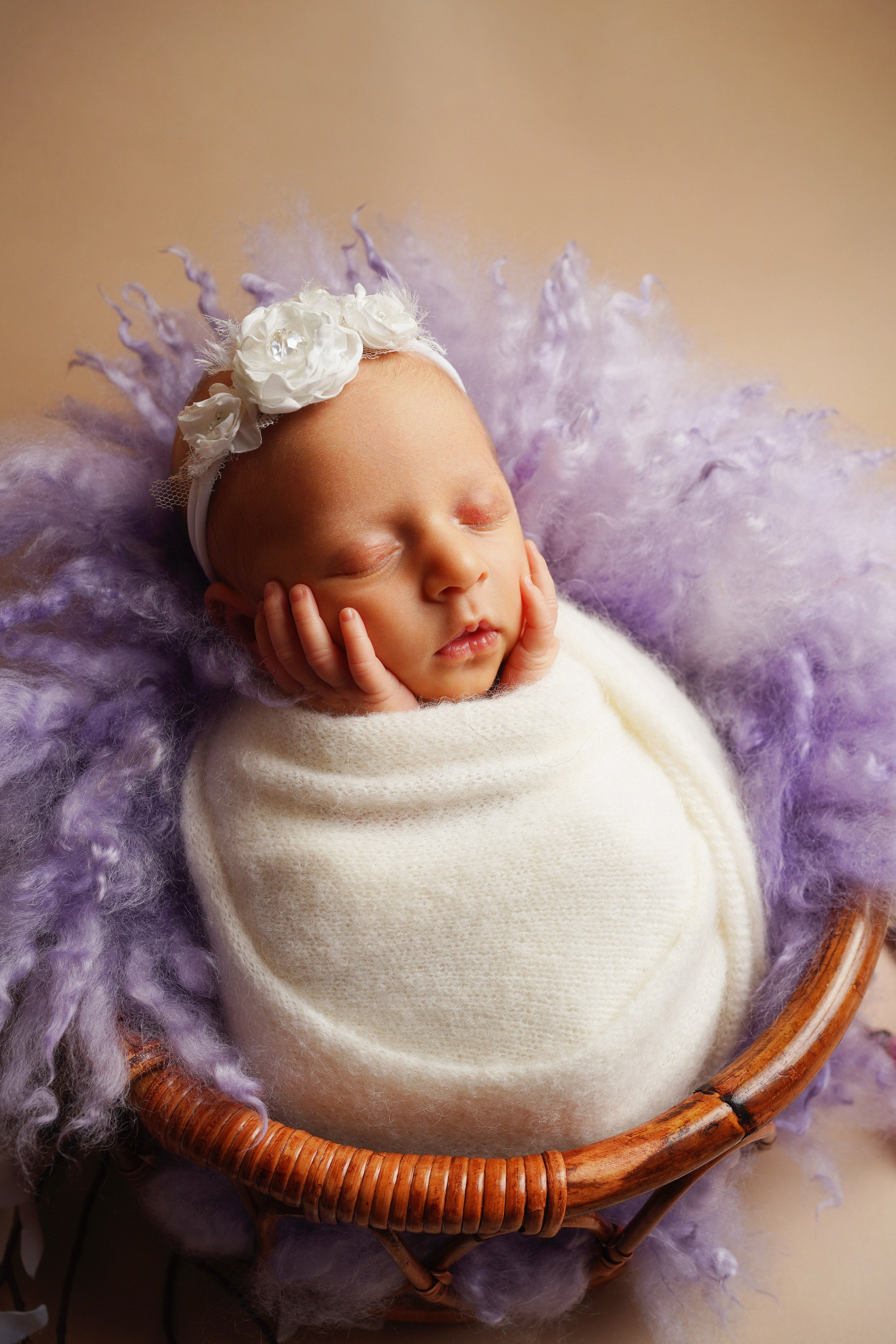 Neugeborenes Baby in Korb mit weichen lila Decken