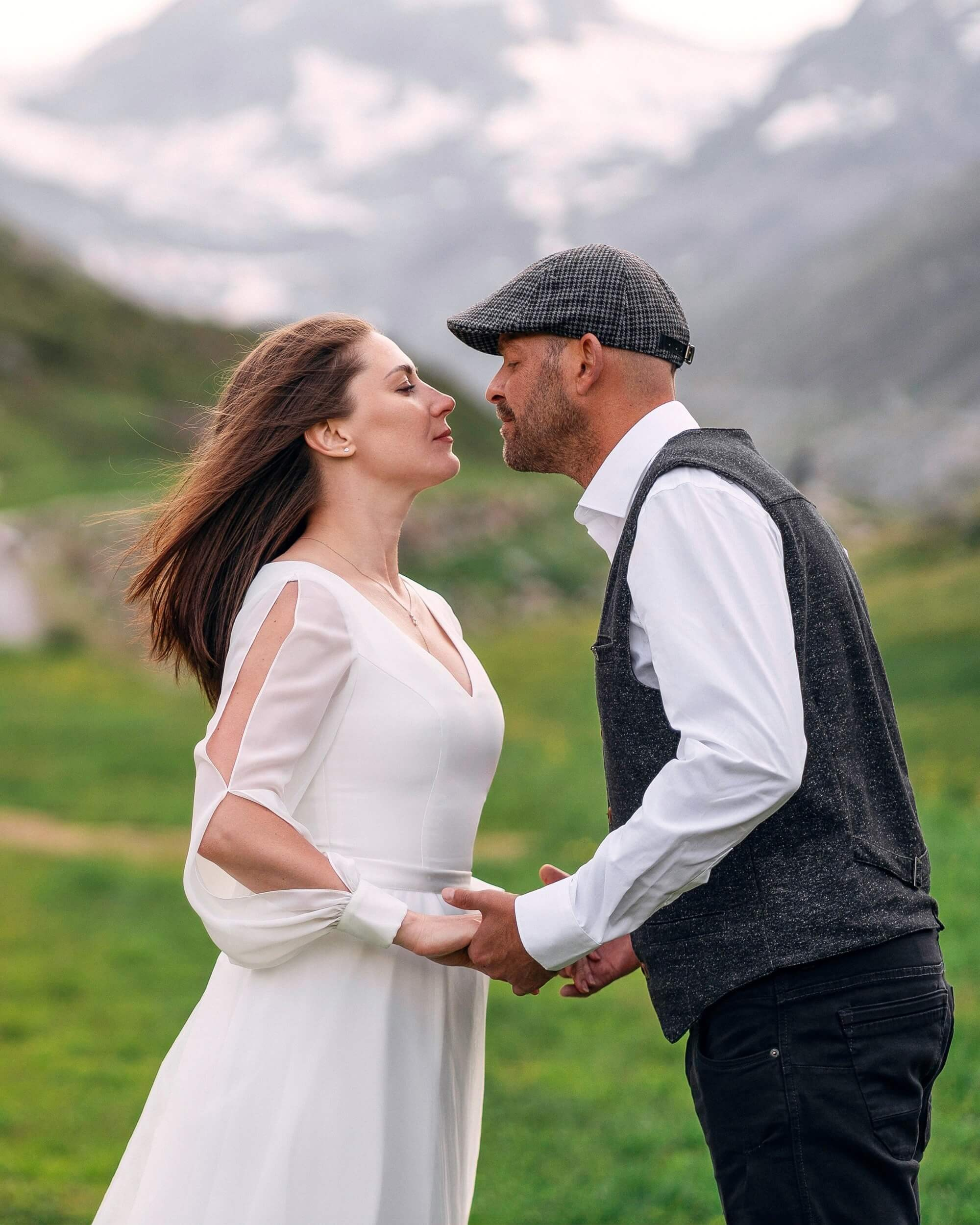 Braut und Bräutigam halten sich an den Händen vor der beeindruckenden Berglandschaft in Sölden.