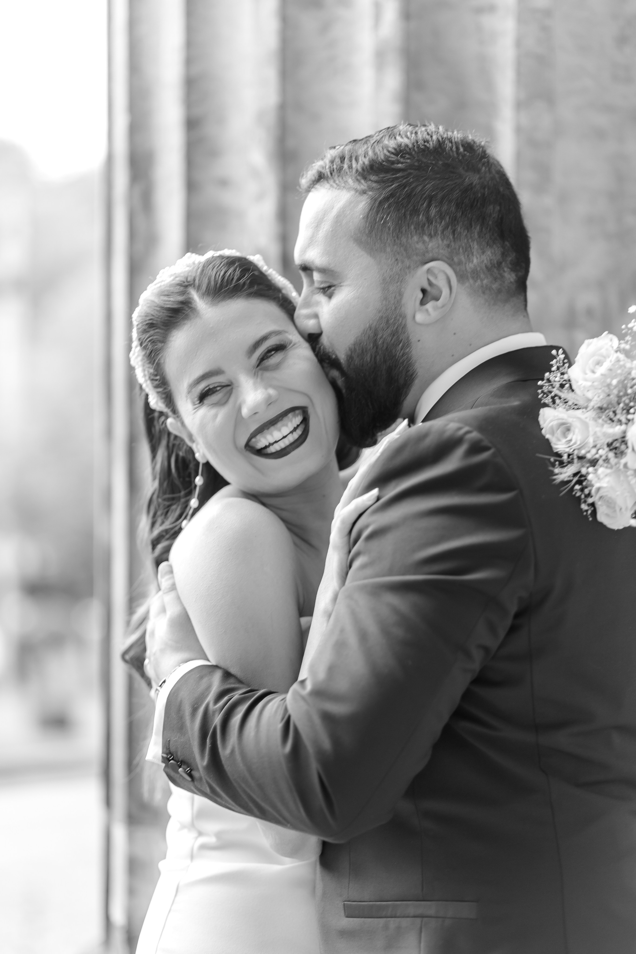 Brautpaar lacht eng umschlungen – Schwarz-Weiß-Hochzeitsfoto in Berlin