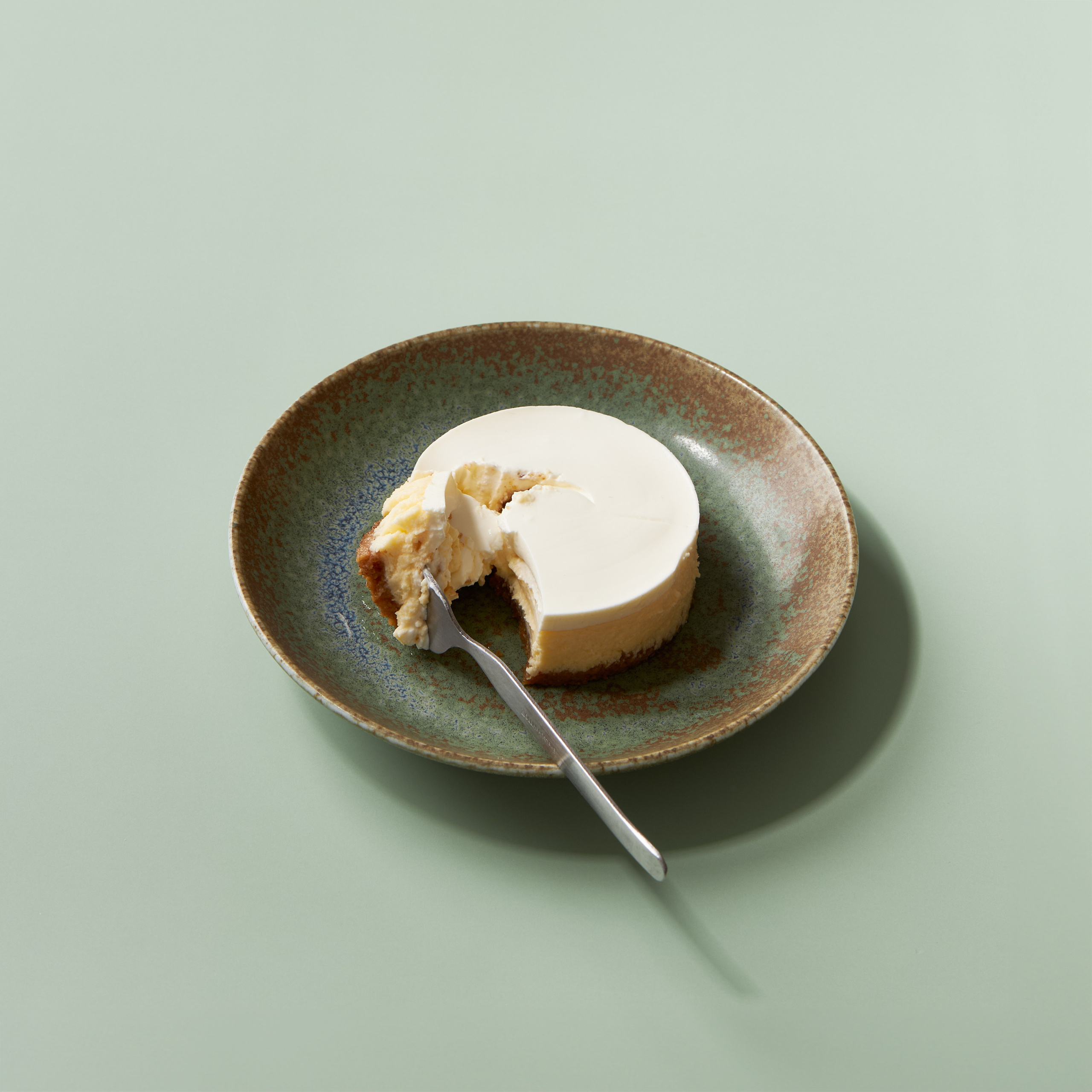 Lifestyle-Foto eines portionierten Cheesecakes auf Teller, Stück verschoben, Content-Fotografie für Social Media, Werbung und Banner