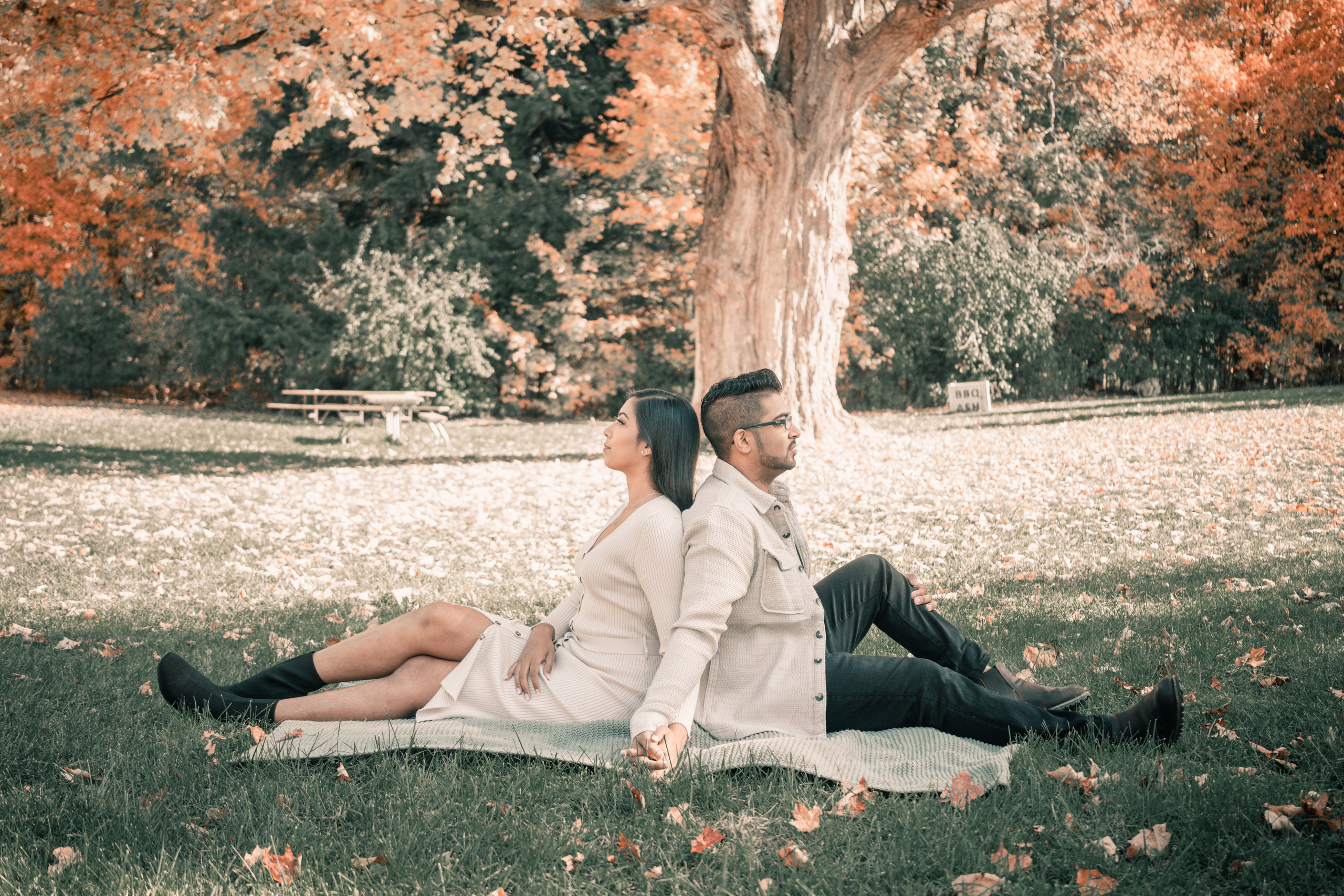 Couple walking through a golden autumn park, capturing their engagement moments