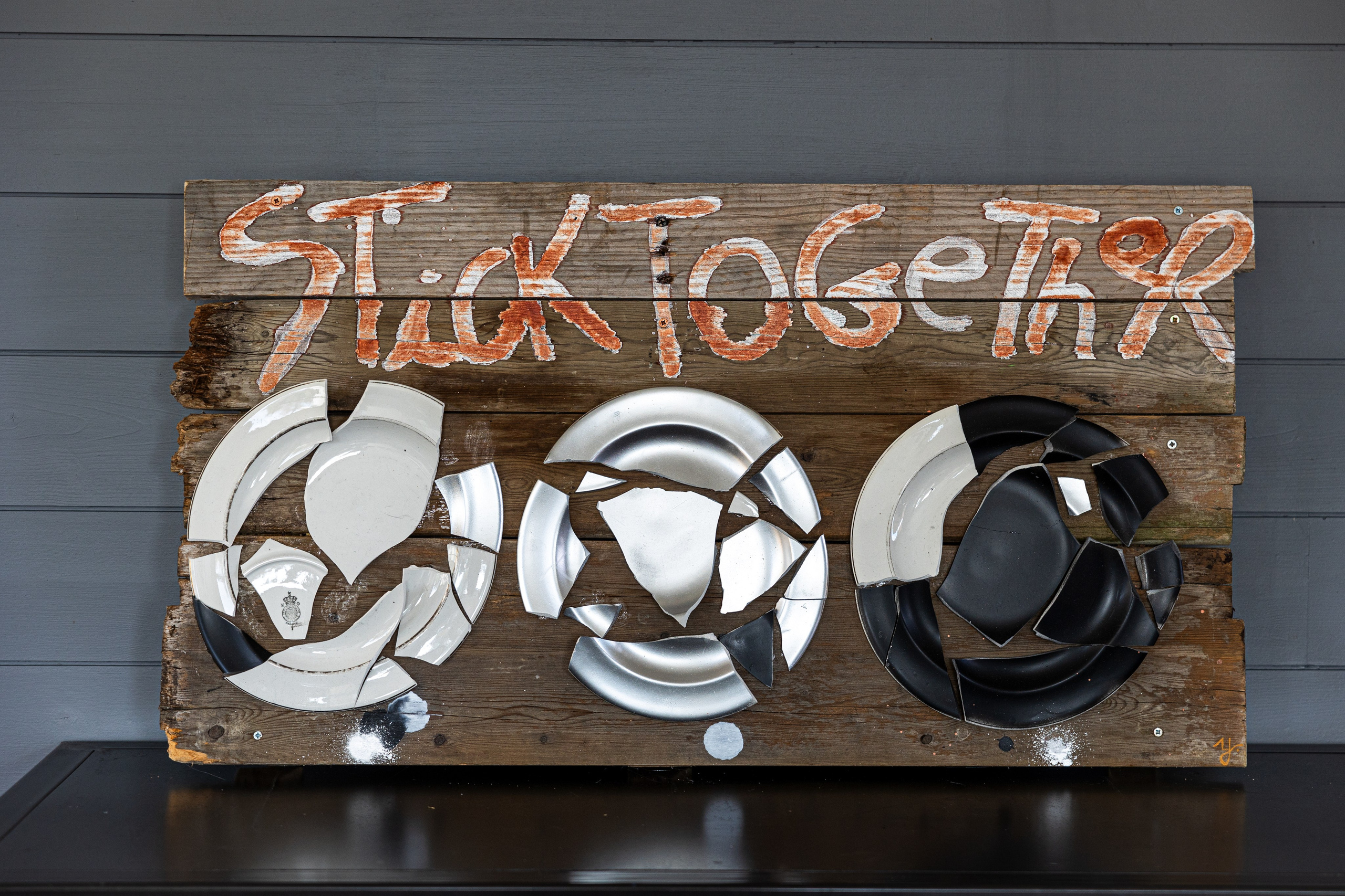 Broken and spray painted plates sticking together 