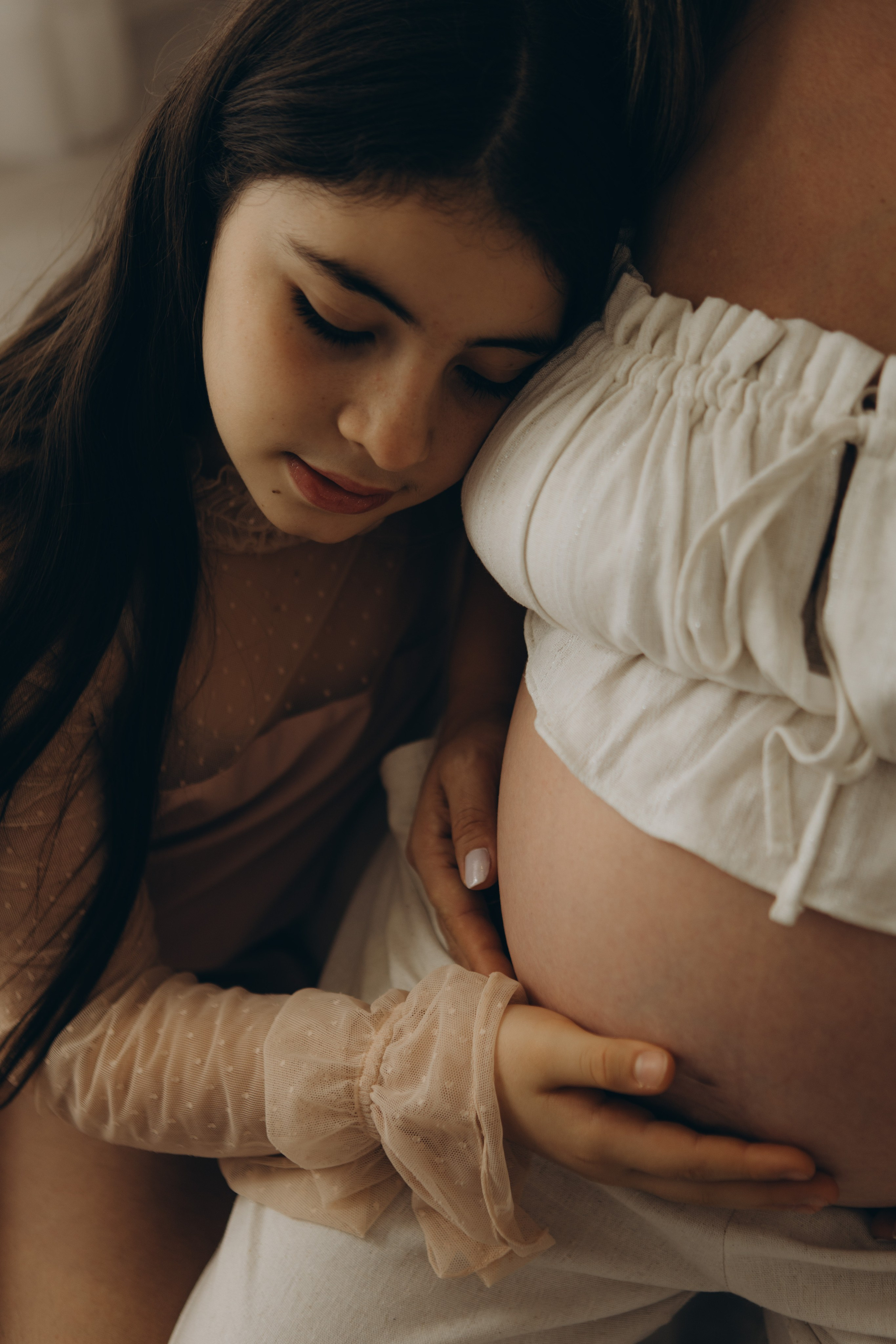 filhos abraçando gestante em ensaio em estúdio em Sorocaba