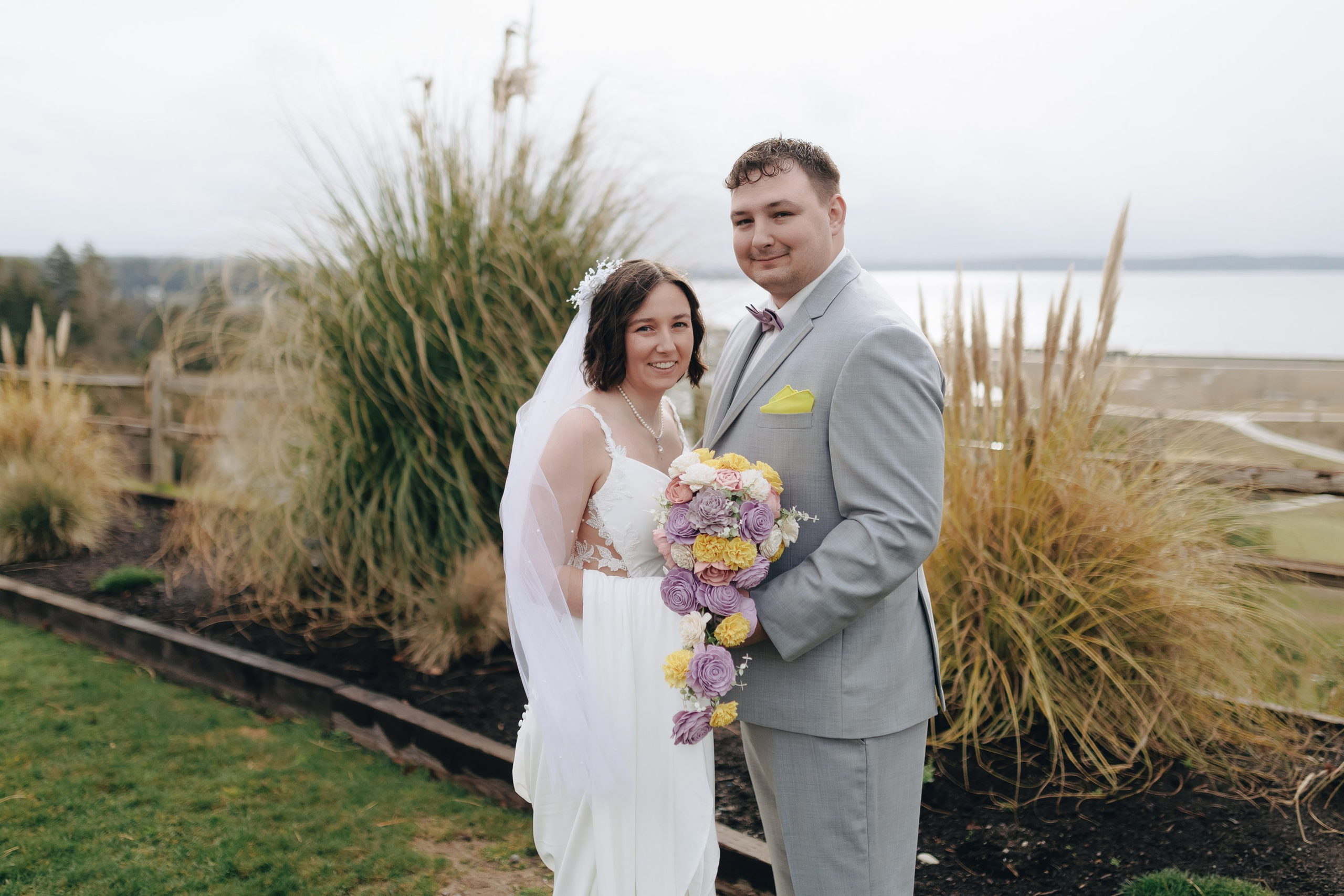Bride and groom standing in field, happy wedding moment