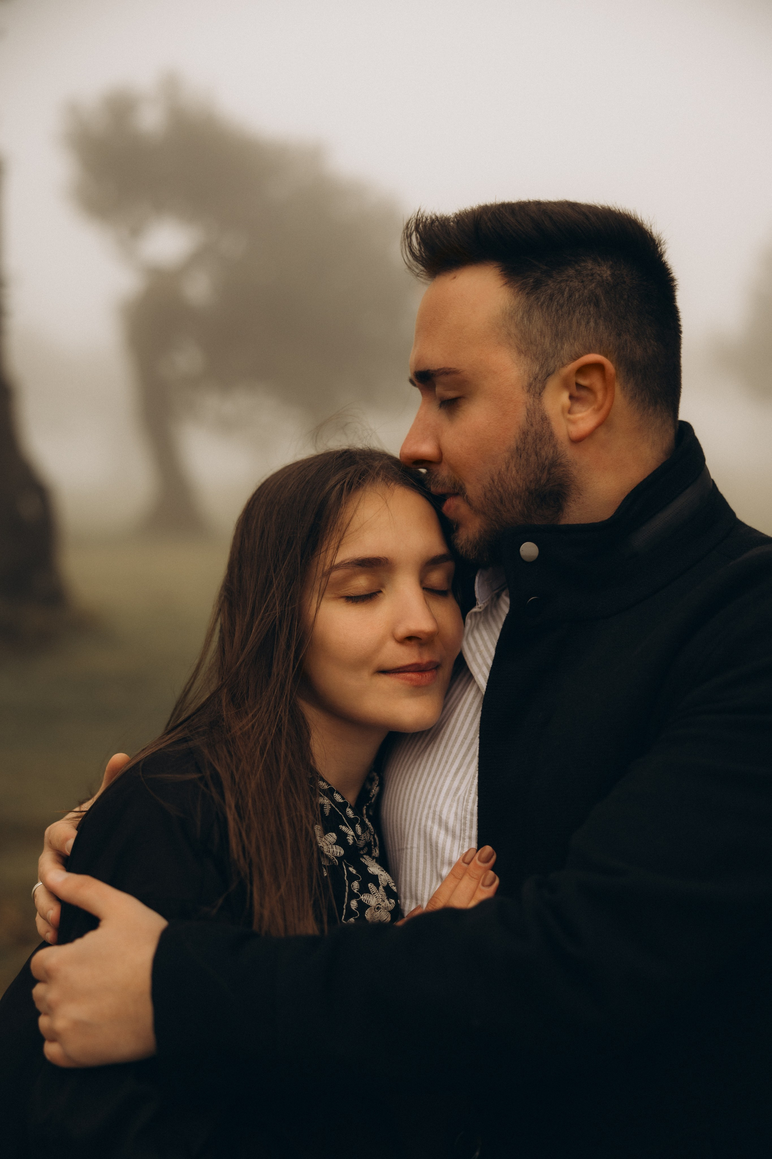 Couple photoshoot in Fanal Forest Madeira PortugalA romantic couple standing amidst the ancient laurel trees of Fanal Forest, Madeira, surrounded by a mystical fog that adds an ethereal touch to the scene
