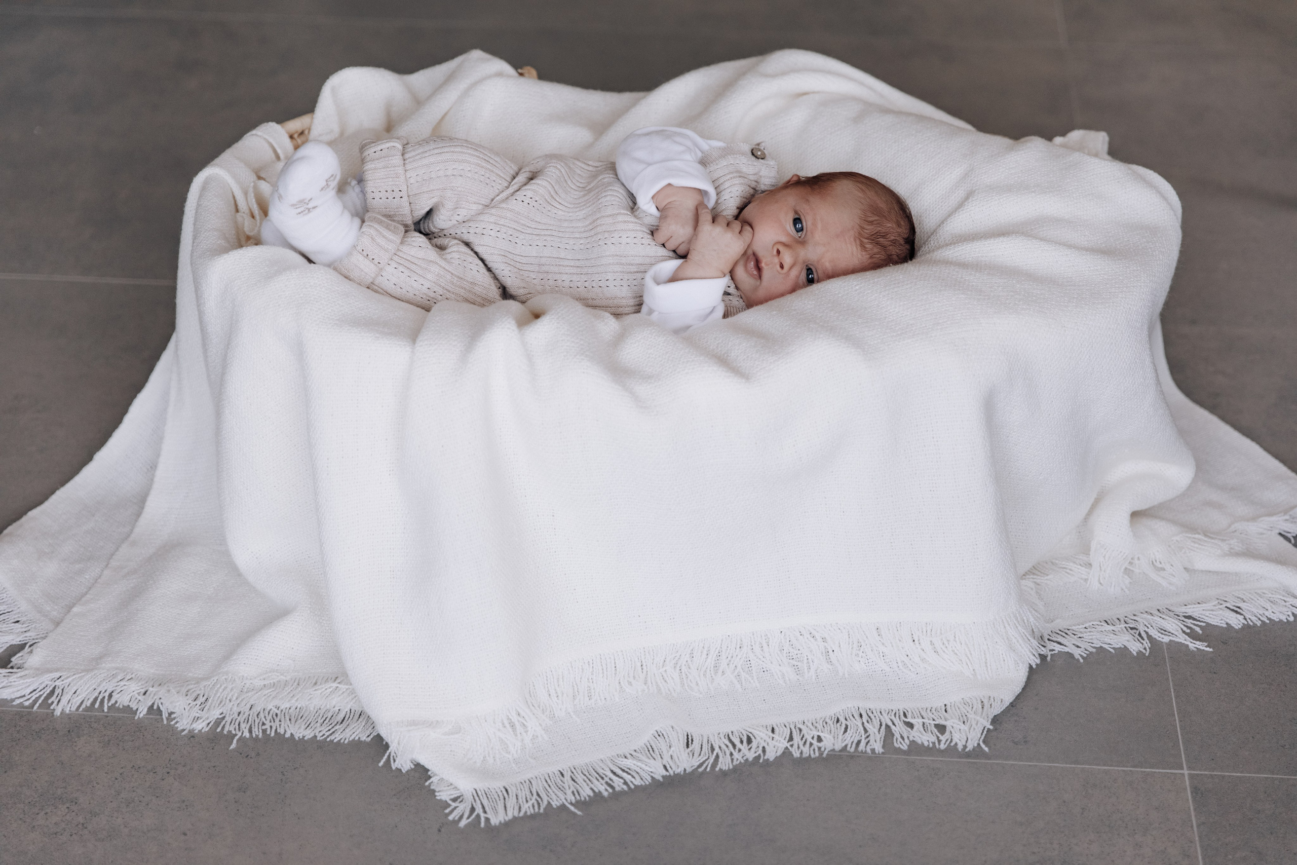 Baby liegt in einem geflochtenen Korb.