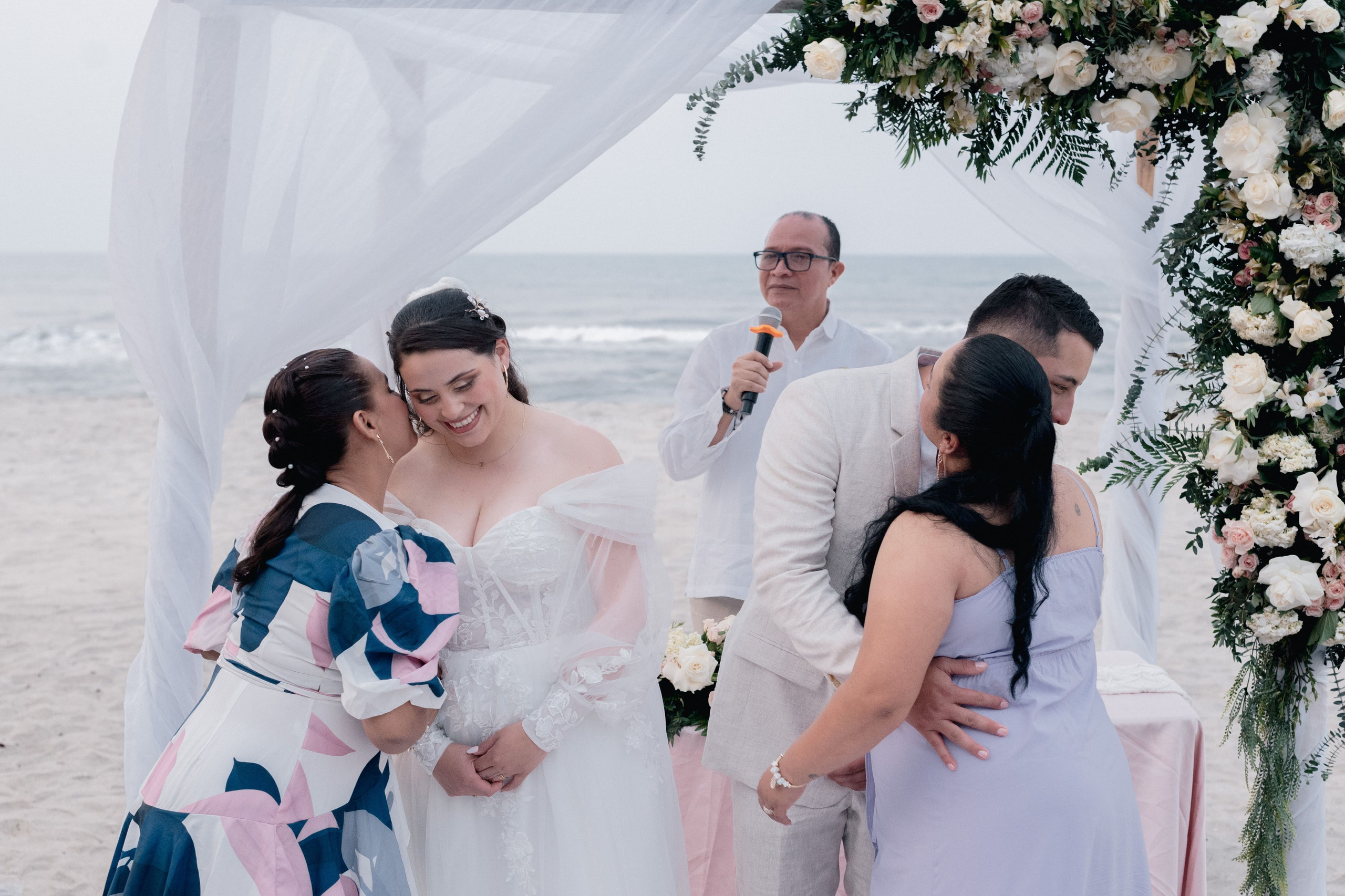 Pareja celebrando en evento de boda de playa, novios disfrutando fiesta matrimonial tropical