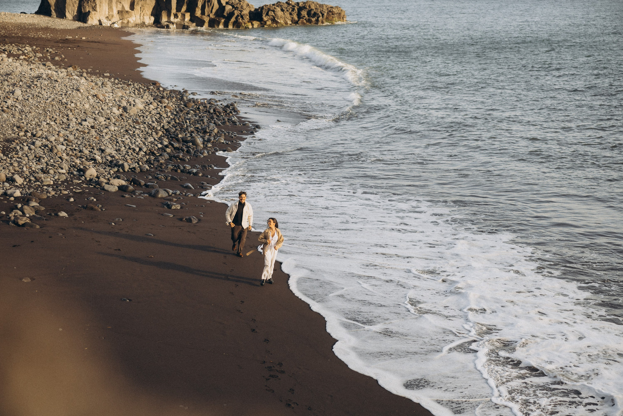Couple sharing a romantic moment during sunset on Madeira Island, with the ocean and cliffs in the background