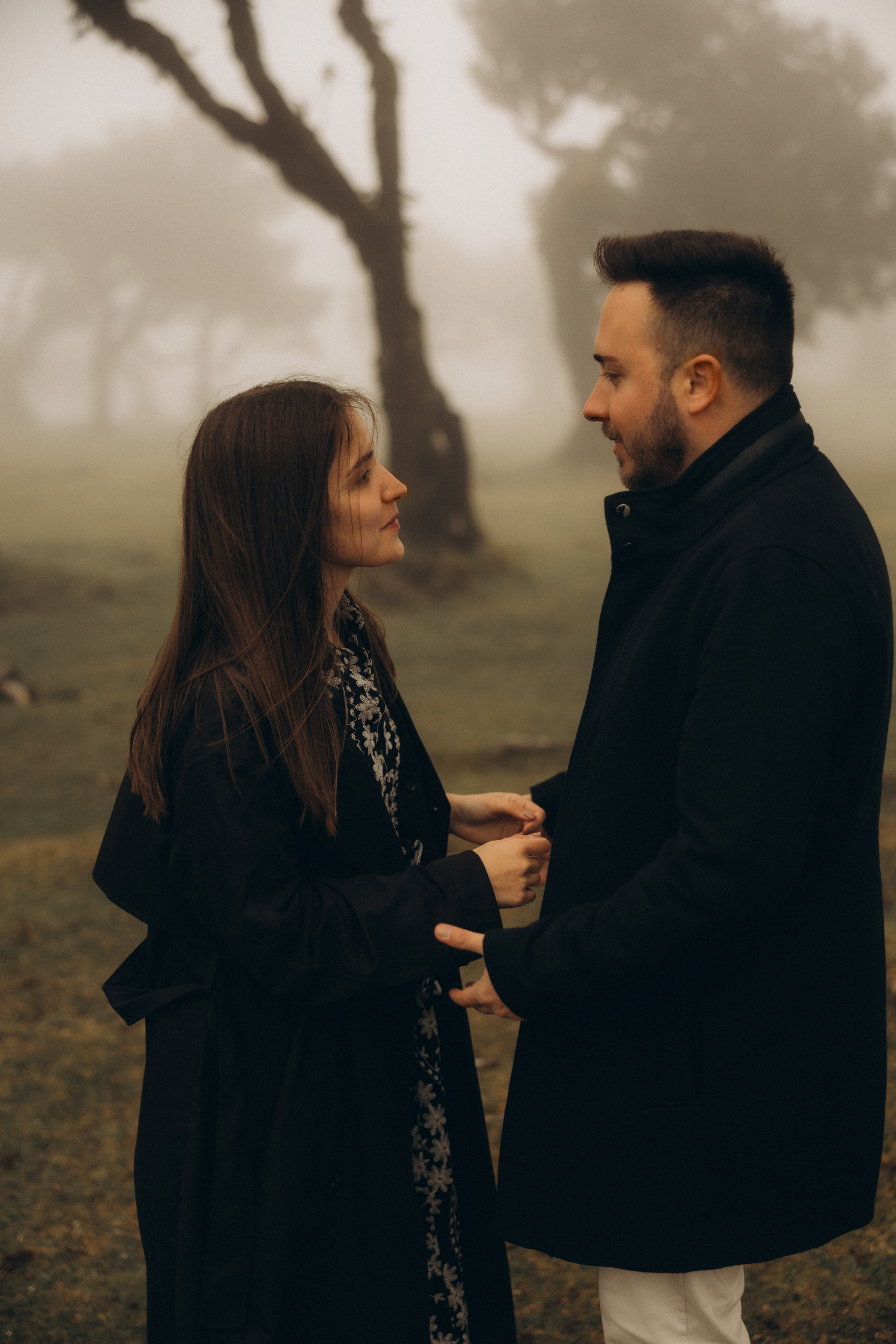 Couple photoshoot in Fanal Forest Madeira PortugalA romantic couple standing amidst the ancient laurel trees of Fanal Forest, Madeira, surrounded by a mystical fog that adds an ethereal touch to the scene