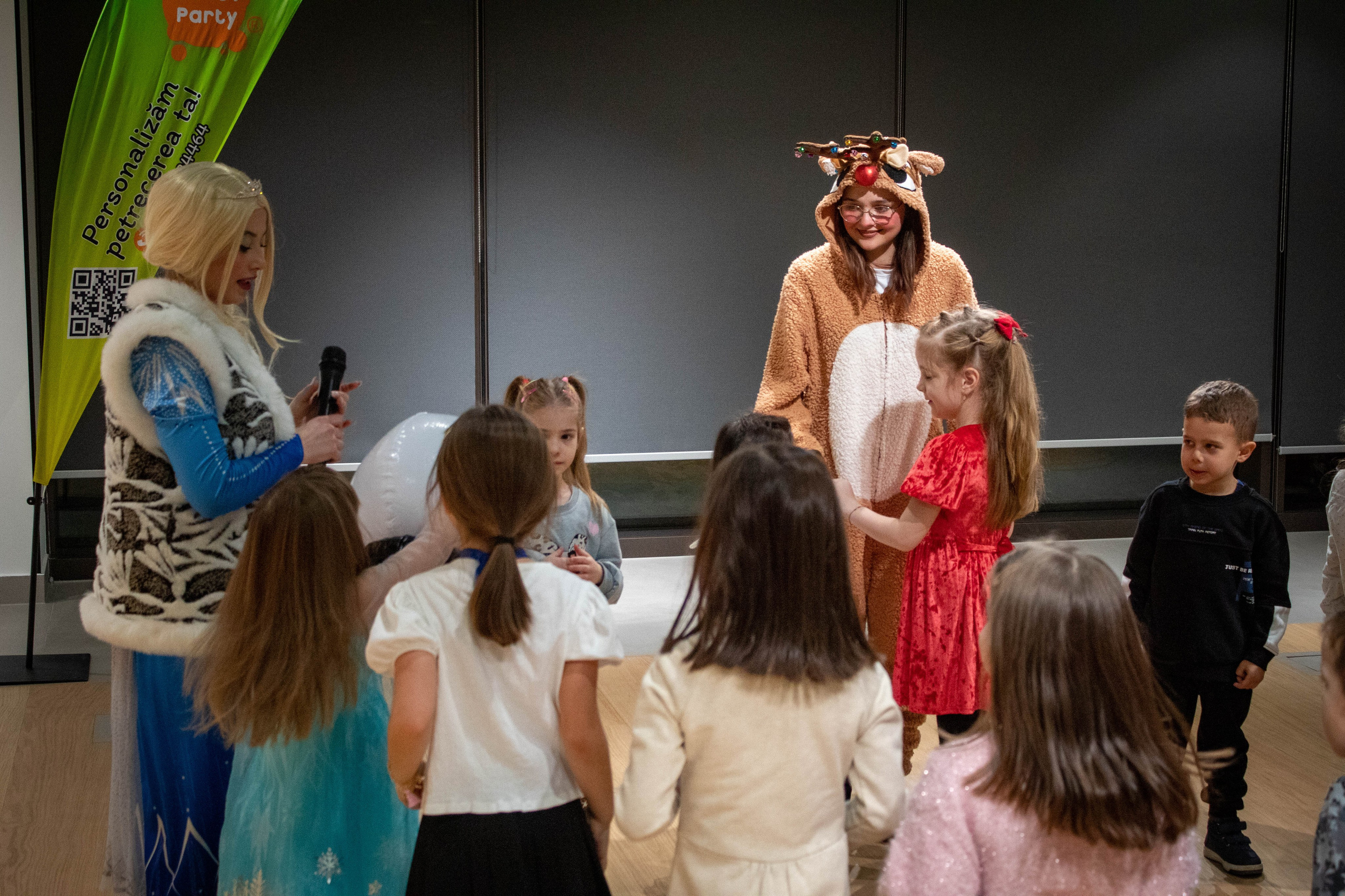 Performers dressed as holiday and fantasy characters posing on stage at a kids’ event.